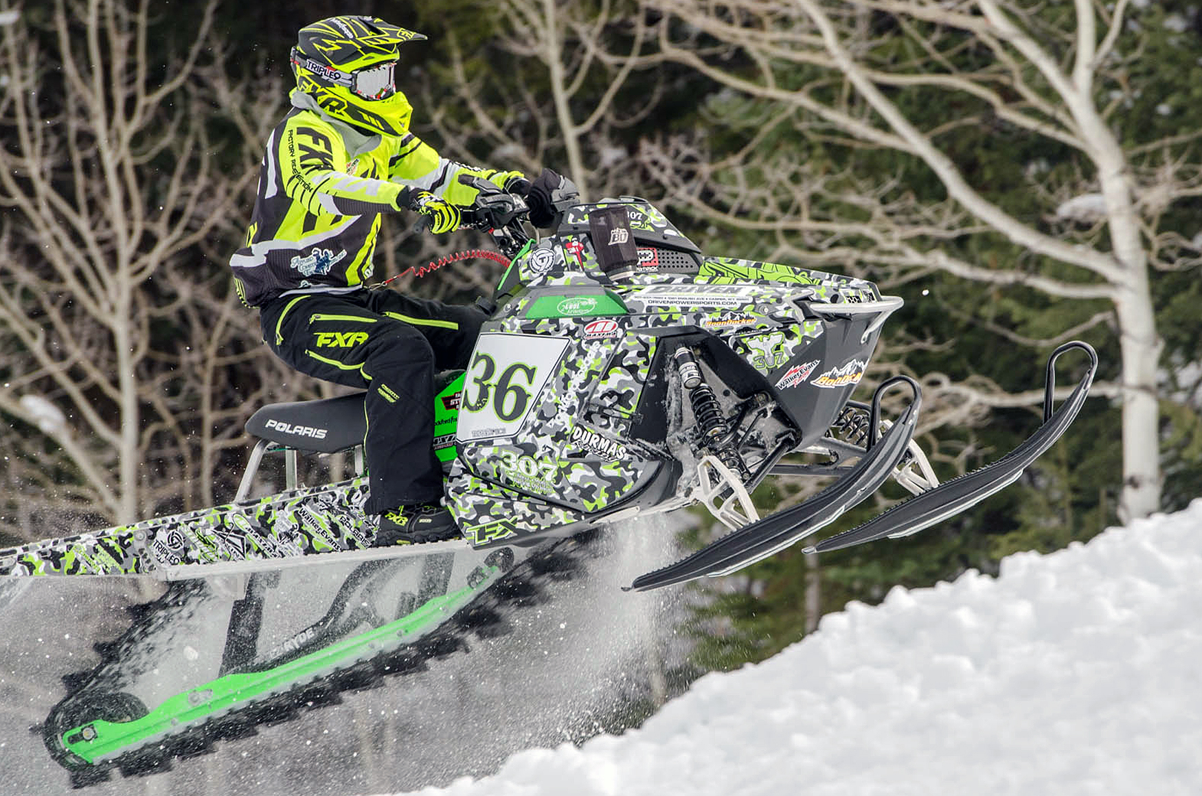 A Polaris Pro-Ride snowmobile with a lime, black, and white Snow Camo custom vinyl wrap.