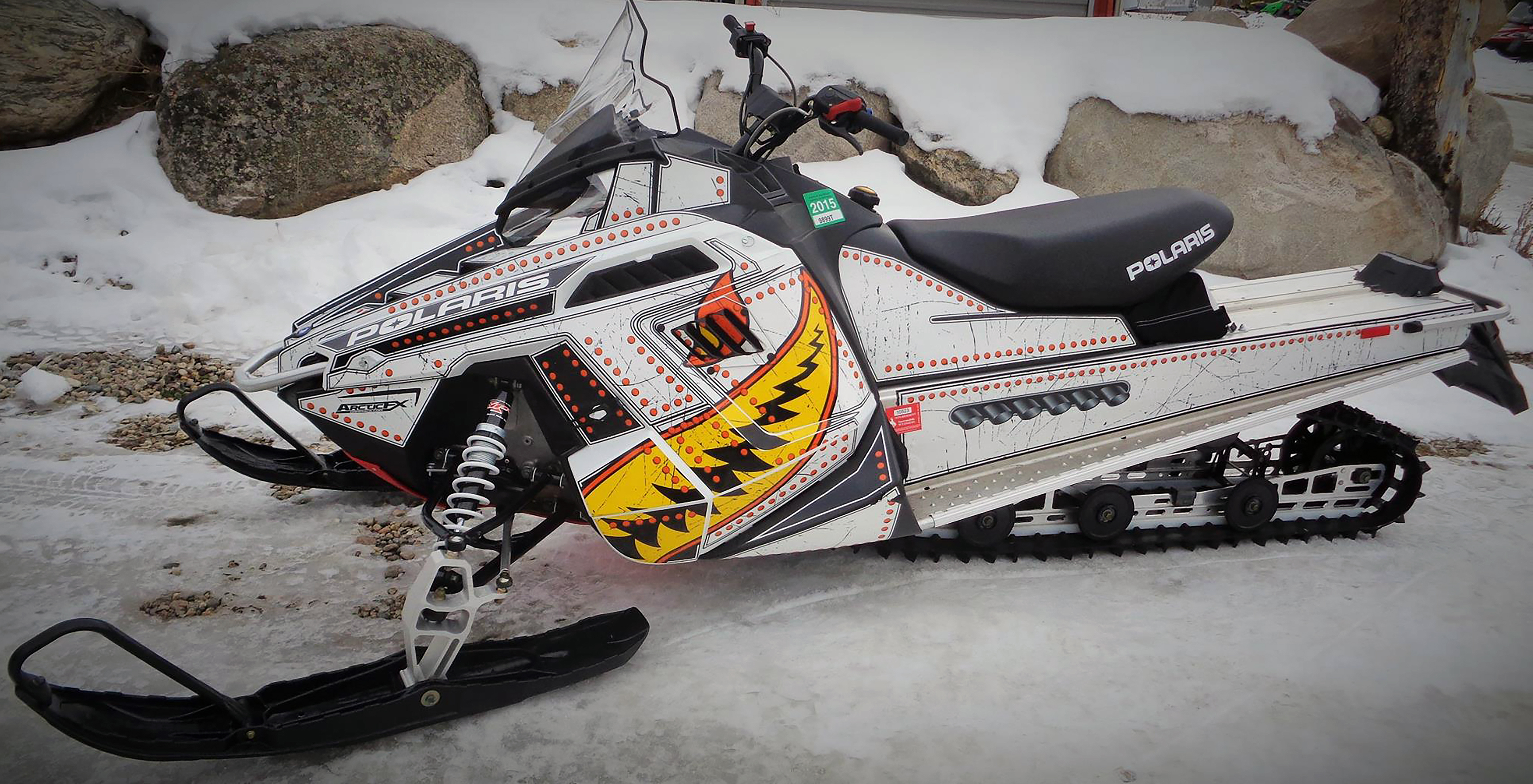 A Polaris Pro-Ride snowmobile with a orange, yellow, black, and white flying tigers Spitfire custom vinyl wrap.