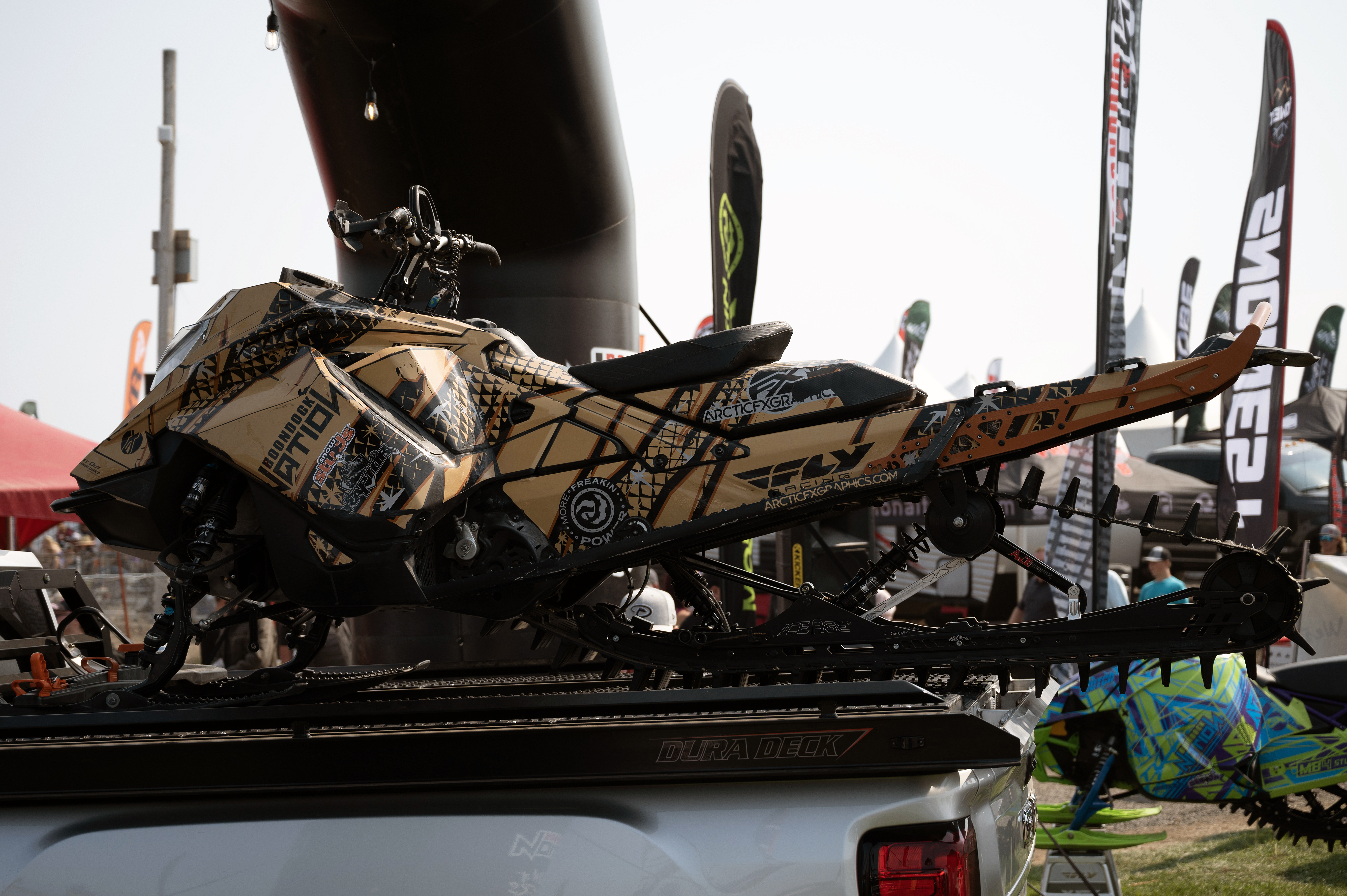 A Ski-Doo Gen4 Lightweight snowmobile with a tan, black, and gray Astro custom vinyl wrap.