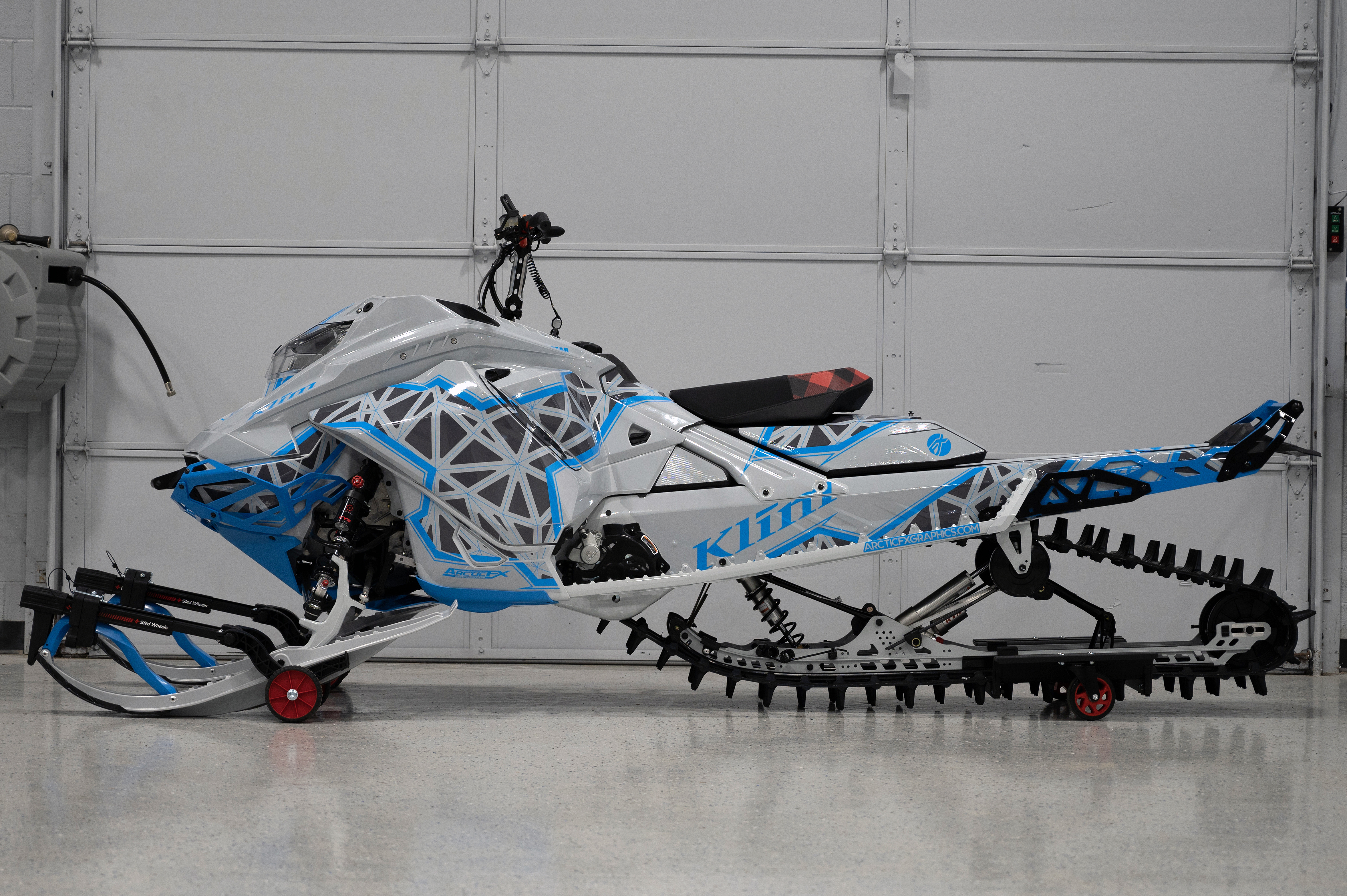 A Ski-Doo Gen4 Lightweight snowmobile with a gray and blue Klim Demolish custom vinyl wrap.