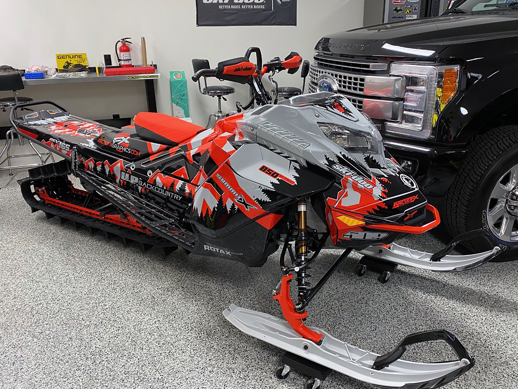 A Ski-Doo Gen4 Lightweight snowmobile with a gray, red, and black Klim Legacy custom vinyl wrap.
