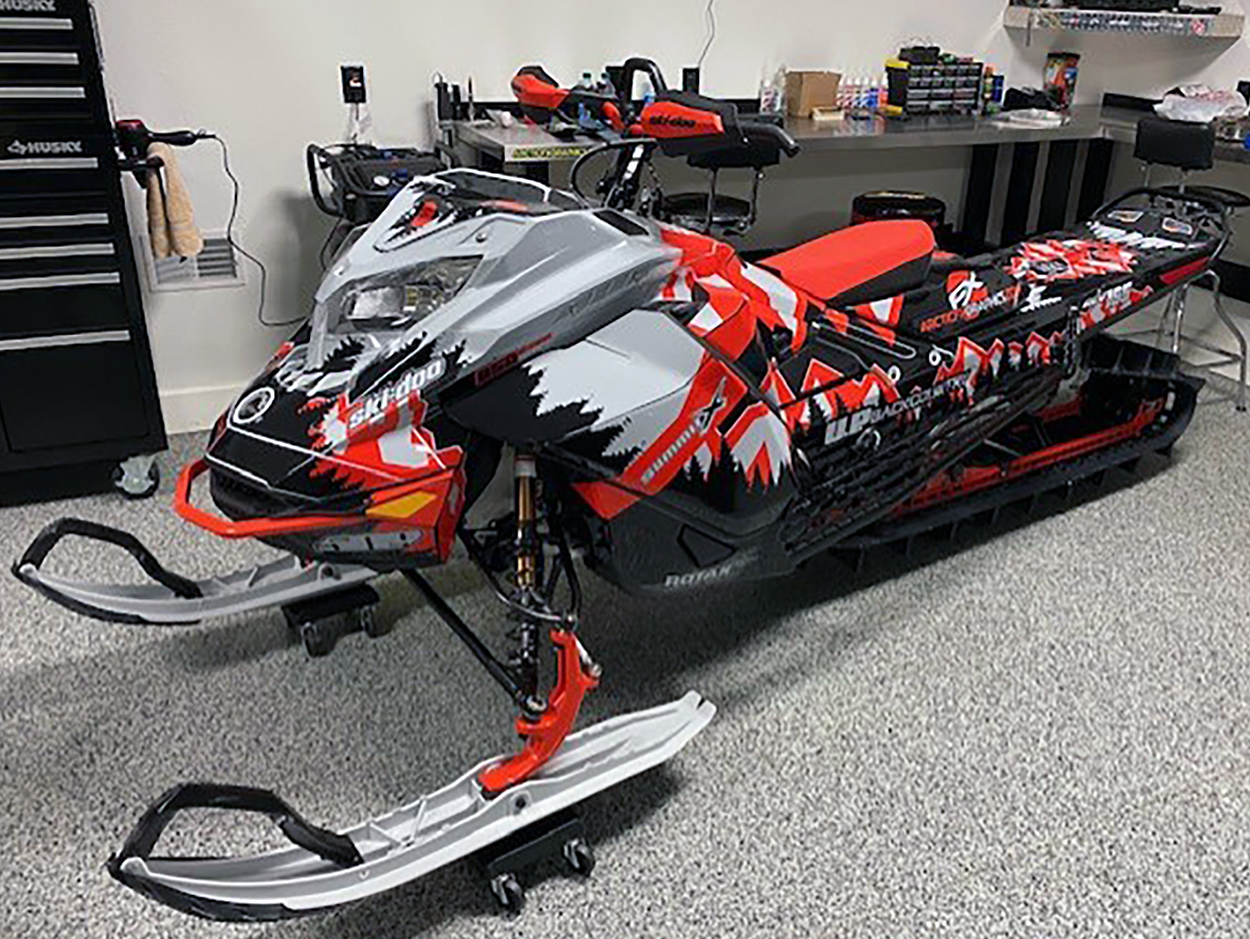 A Ski-Doo Gen4 Lightweight snowmobile with a gray, red, and black Klim Legacy custom vinyl wrap.
