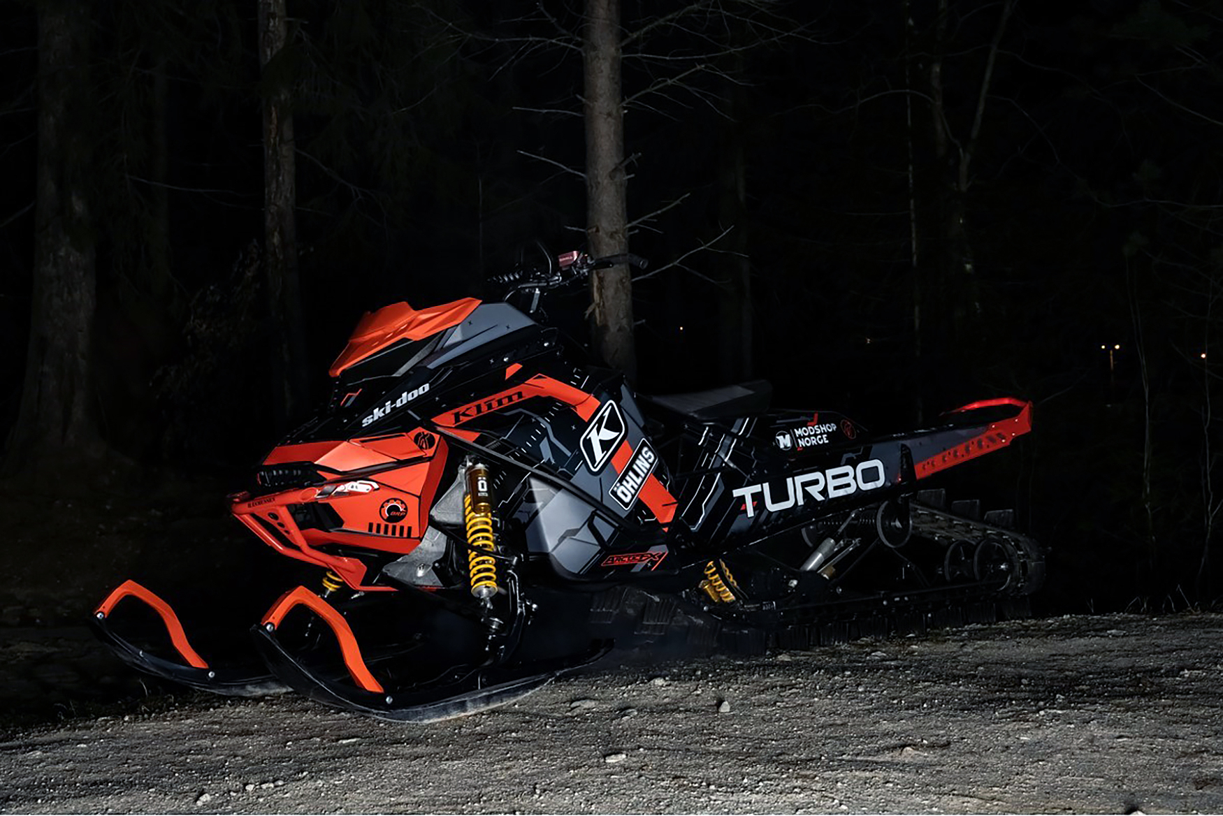 A Ski-Doo Gen4 Lightweight snowmobile with a gray, red, and black Klim Recoil custom vinyl wrap.