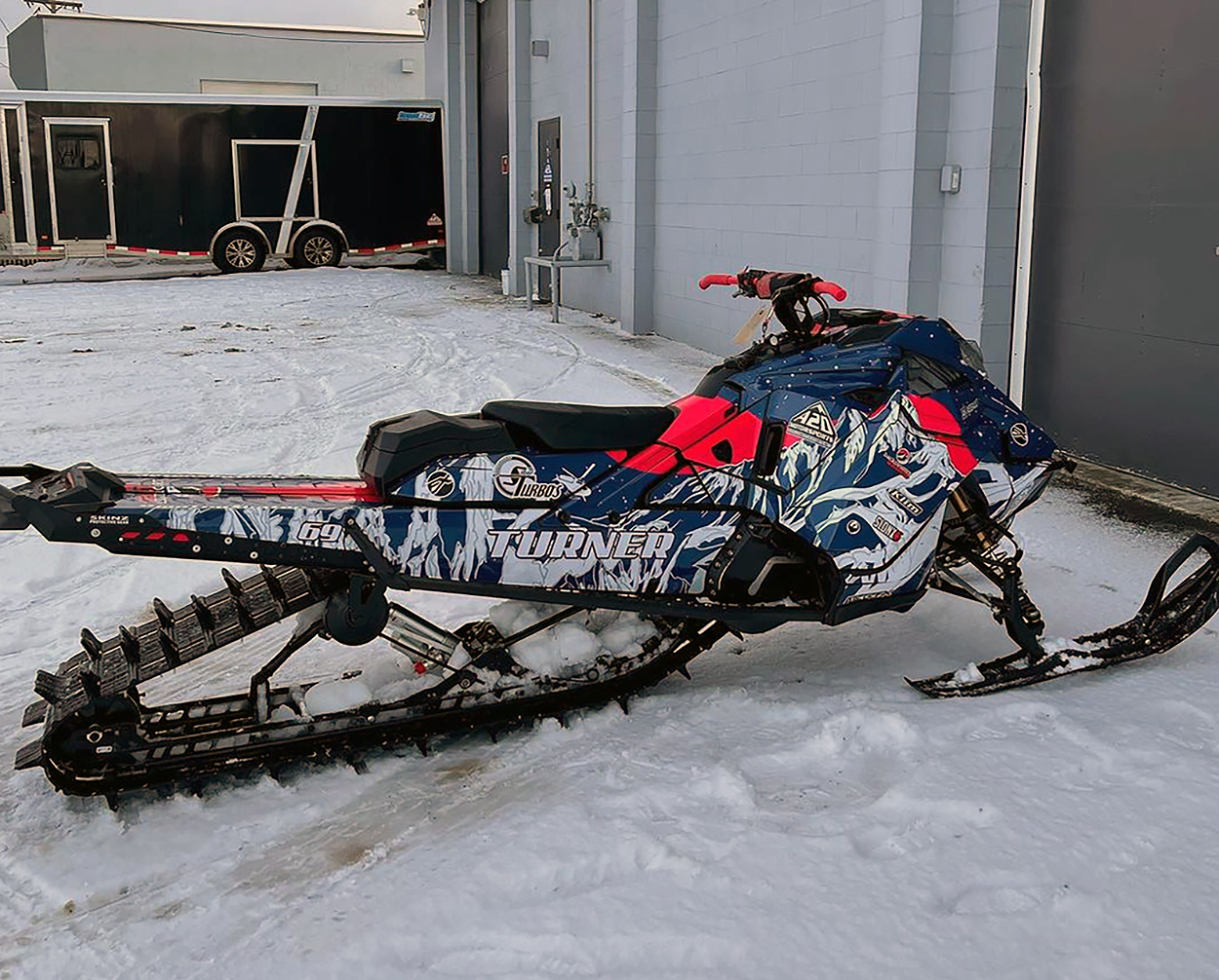 A Ski-Doo Gen4 Lightweight snowmobile with a red, navy, and white Sherman AK Assault custom vinyl wrap.