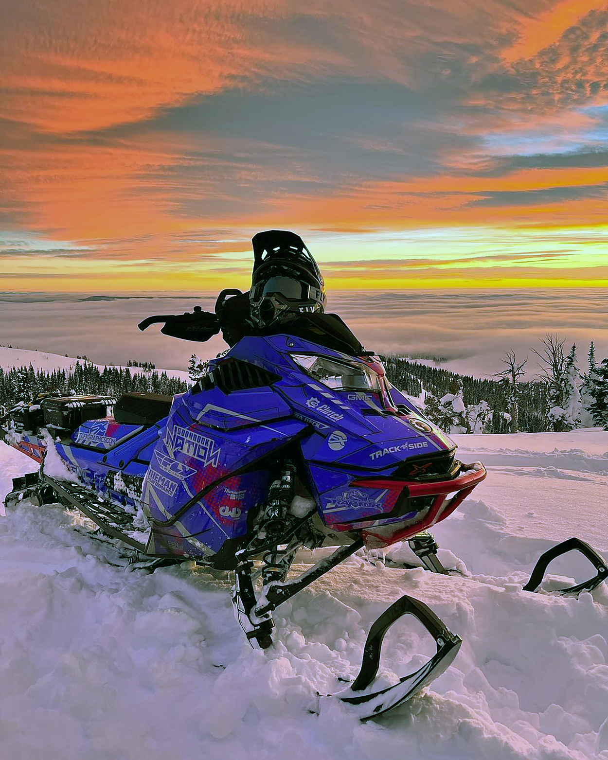 A Ski-Doo Gen4 Lightweight snowmobile with a blue, red, and gray Vision custom vinyl wrap.