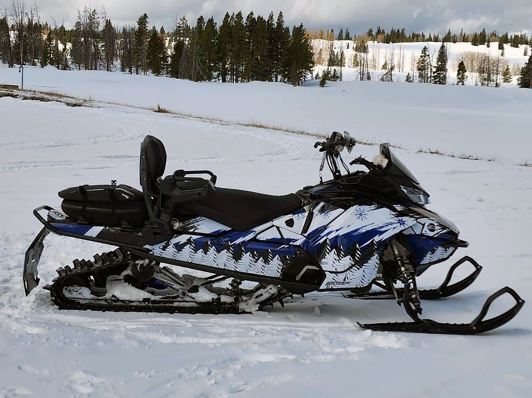 A Ski-Doo Gen4 Narrow Body snowmobile with a blue, black, and white Absolute Zero custom vinyl wrap.