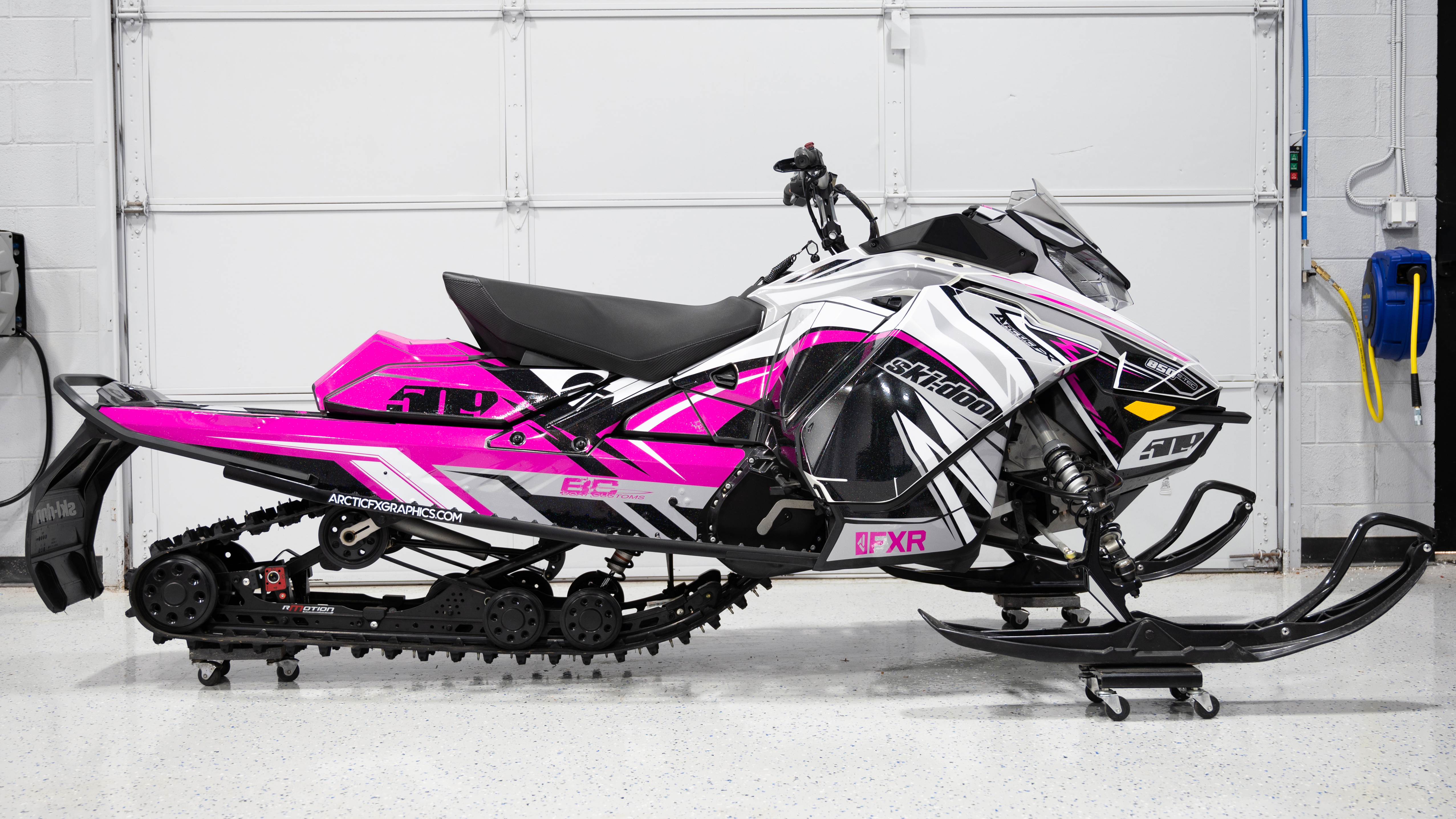A Ski-Doo Gen4 Narrow Body snowmobile with a pink, white, and black Kesterke Adrenaline custom vinyl wrap.