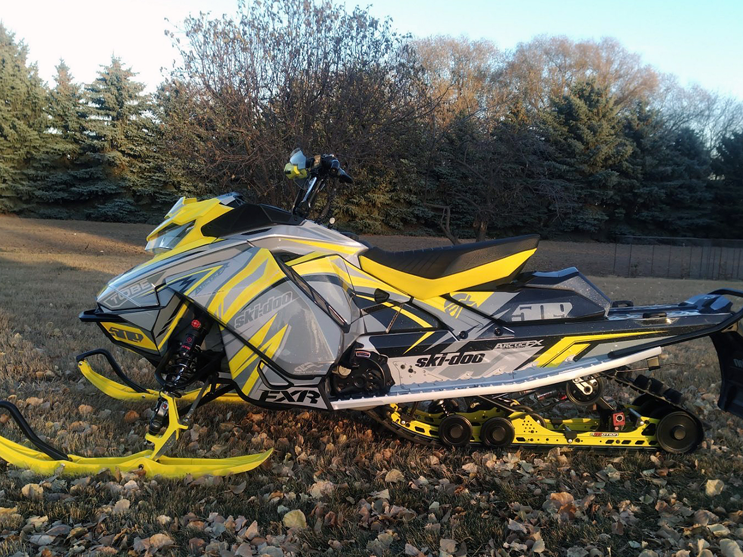 A Ski-Doo Gen4 Narrow Body snowmobile with a yellow, gray, and black Kesterke Adrenaline custom vinyl wrap.