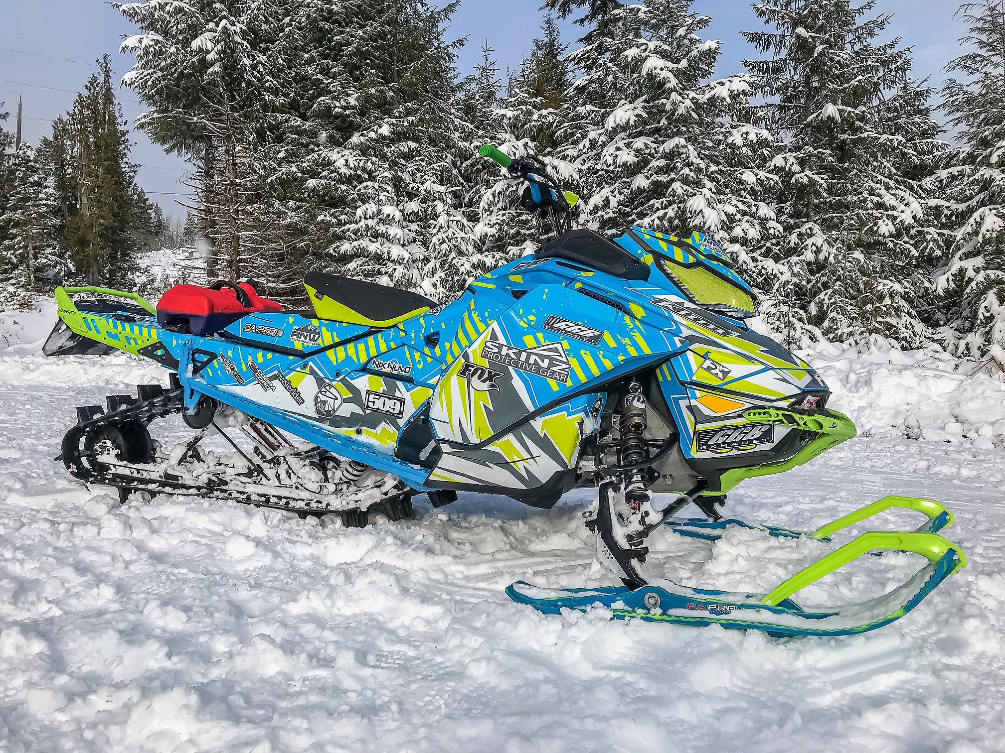 A Ski-Doo Gen4 Narrow Body snowmobile with a octane blue, manta, and white Altitude custom vinyl wrap.