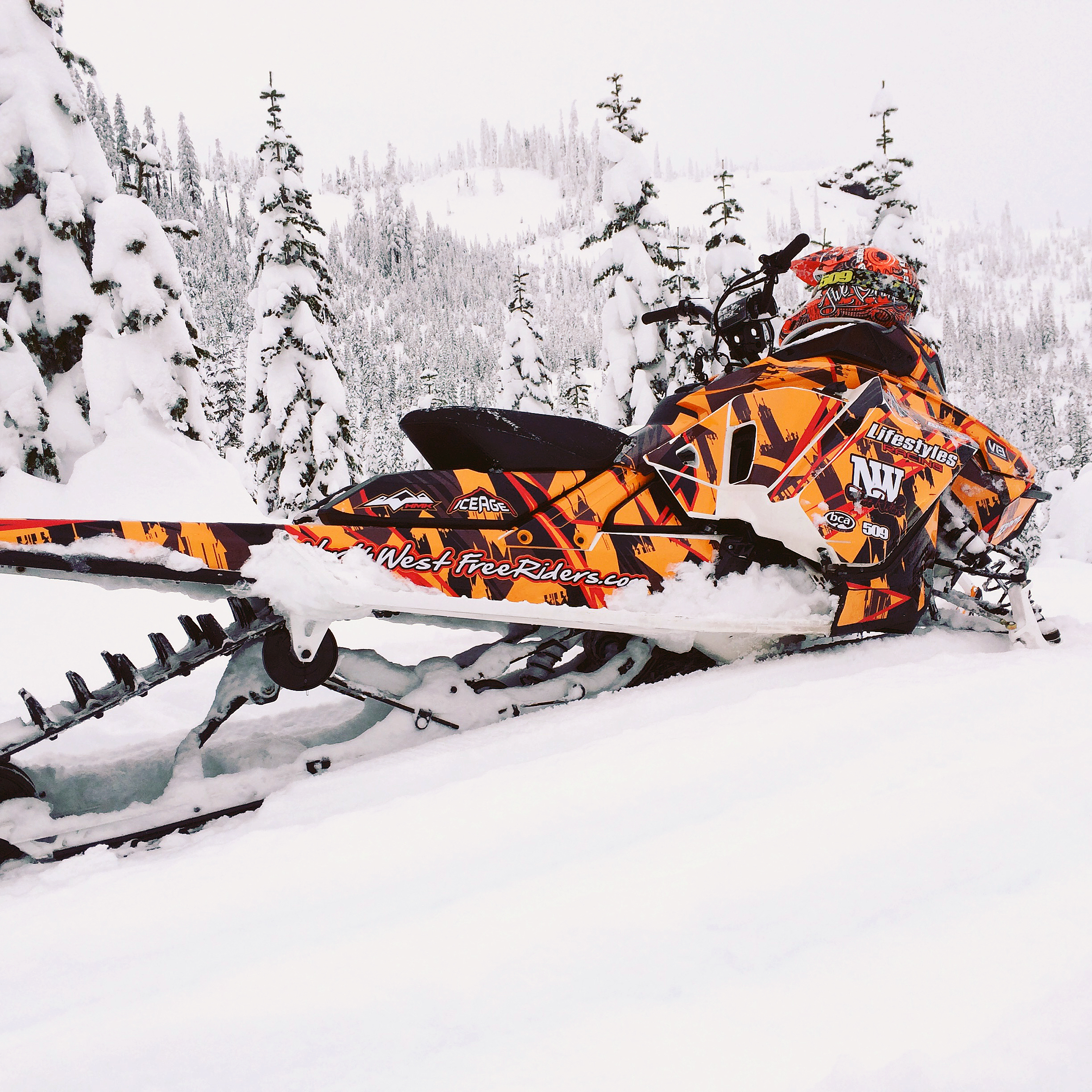A Ski-Doo Gen4 Narrow Body snowmobile with a orange, black, and red Insidious custom vinyl wrap.