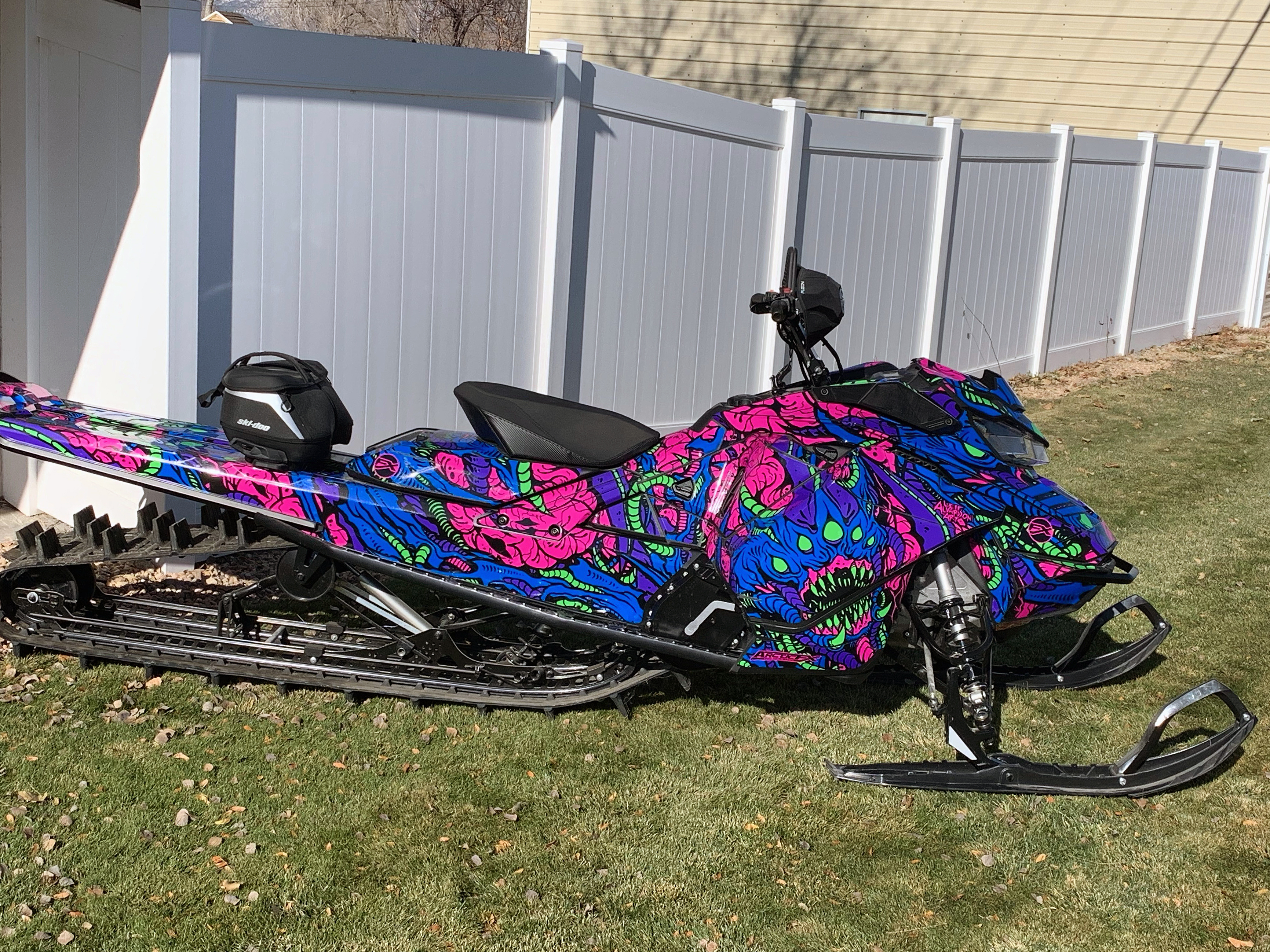 A Ski-Doo Gen4 Narrow Body snowmobile with a blue, pink, and black Leif Alvarsson Area 51 custom vinyl wrap.
