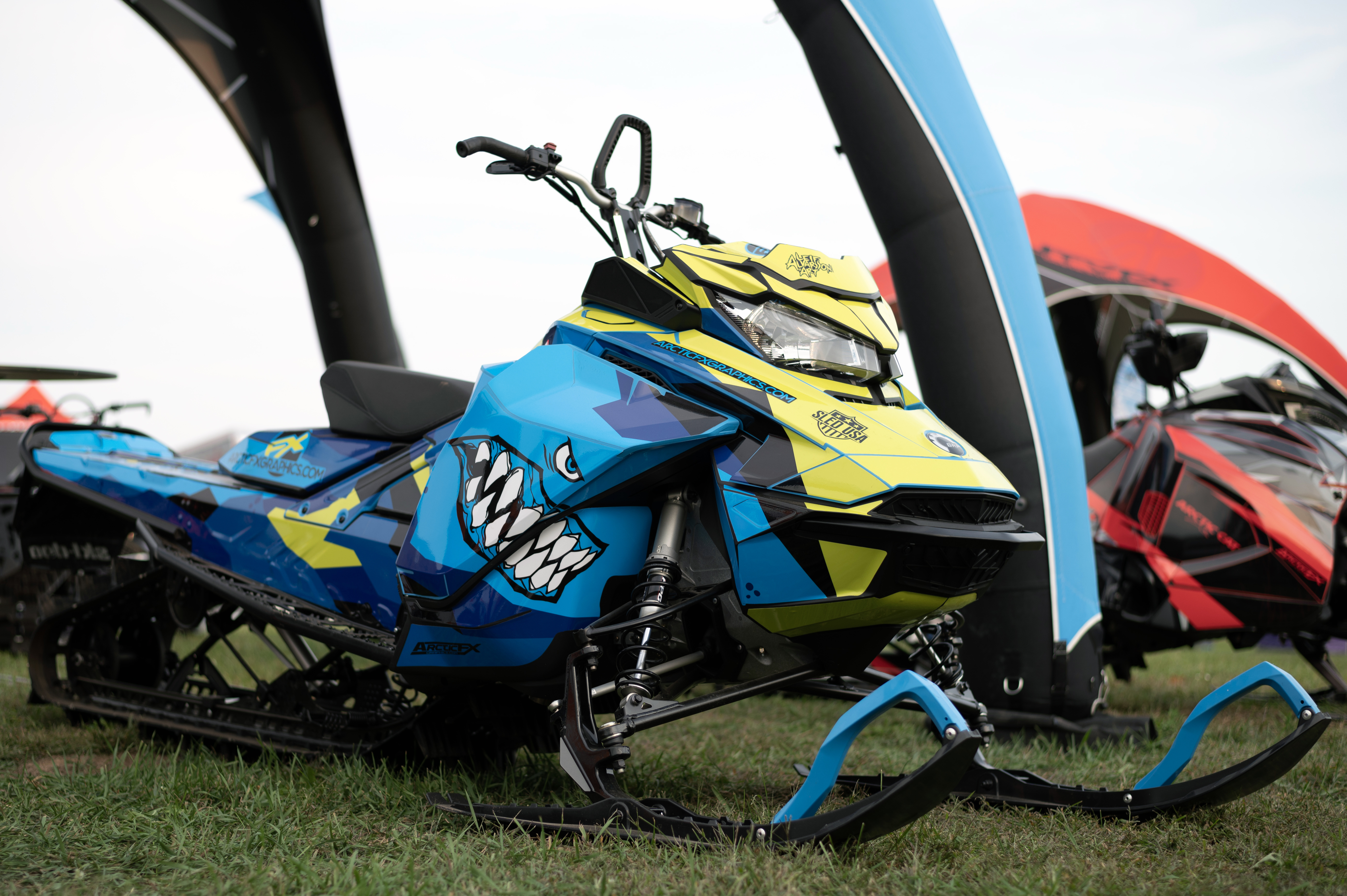 A Ski-Doo Gen4 Narrow Body snowmobile with a octane blue, yellow, and black Leif Alvarsson Landshark custom vinyl wrap.