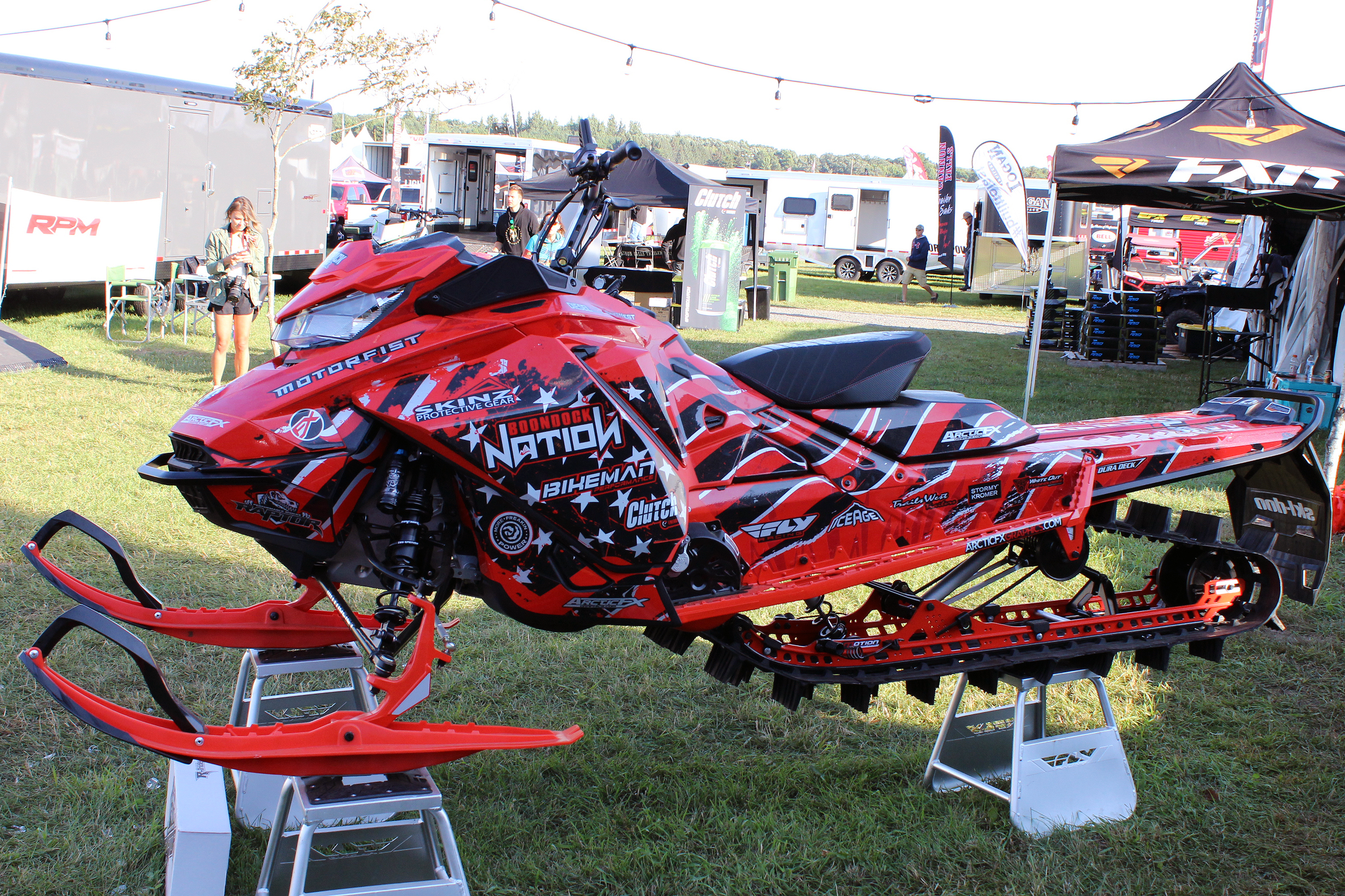 A Ski-Doo Gen4 Narrow Body snowmobile with a red, gray, and black American Flag custom vinyl wrap.