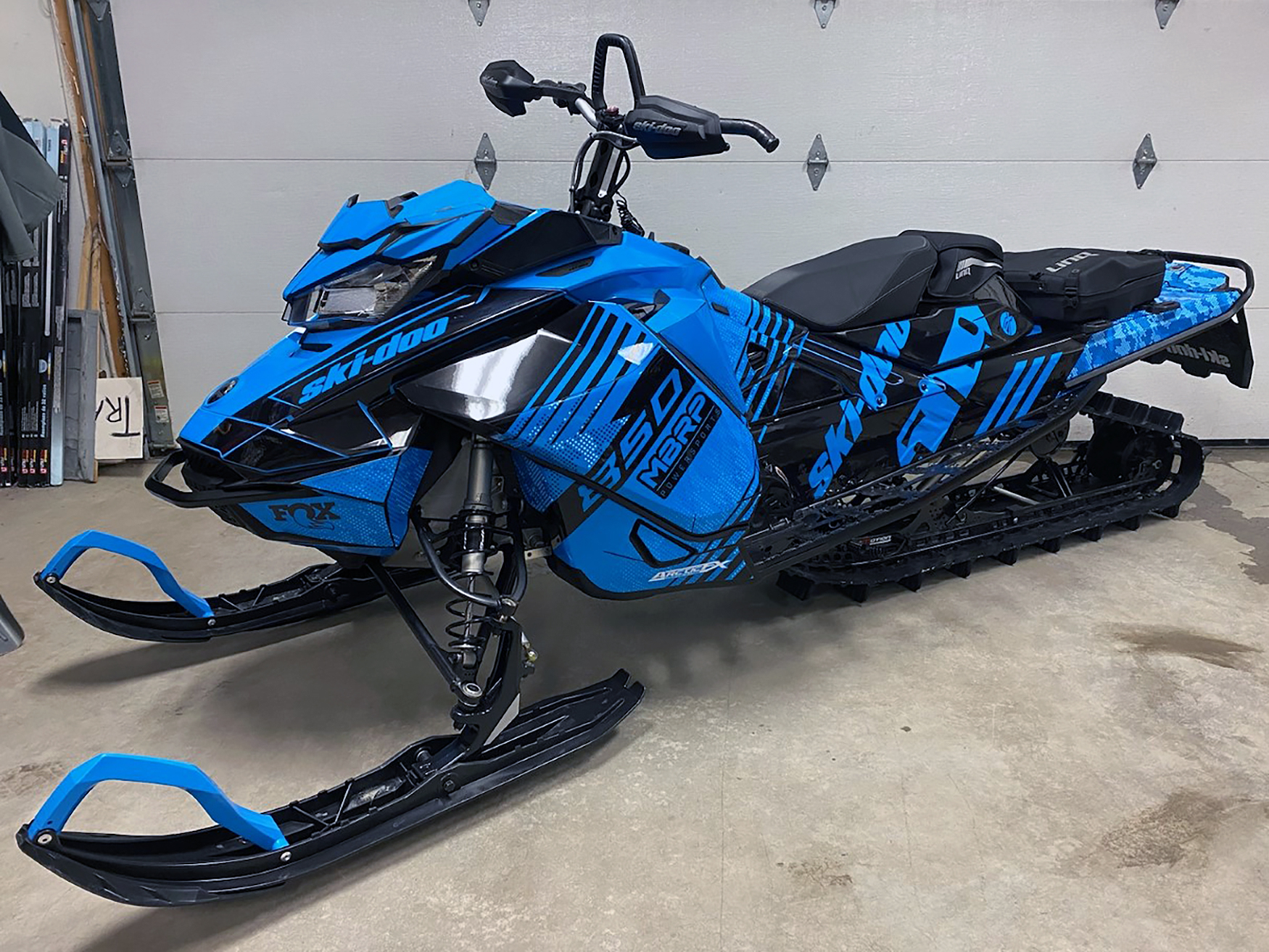 A Ski-Doo Gen4 Narrow Body snowmobile with a black and blue Armada custom vinyl wrap.