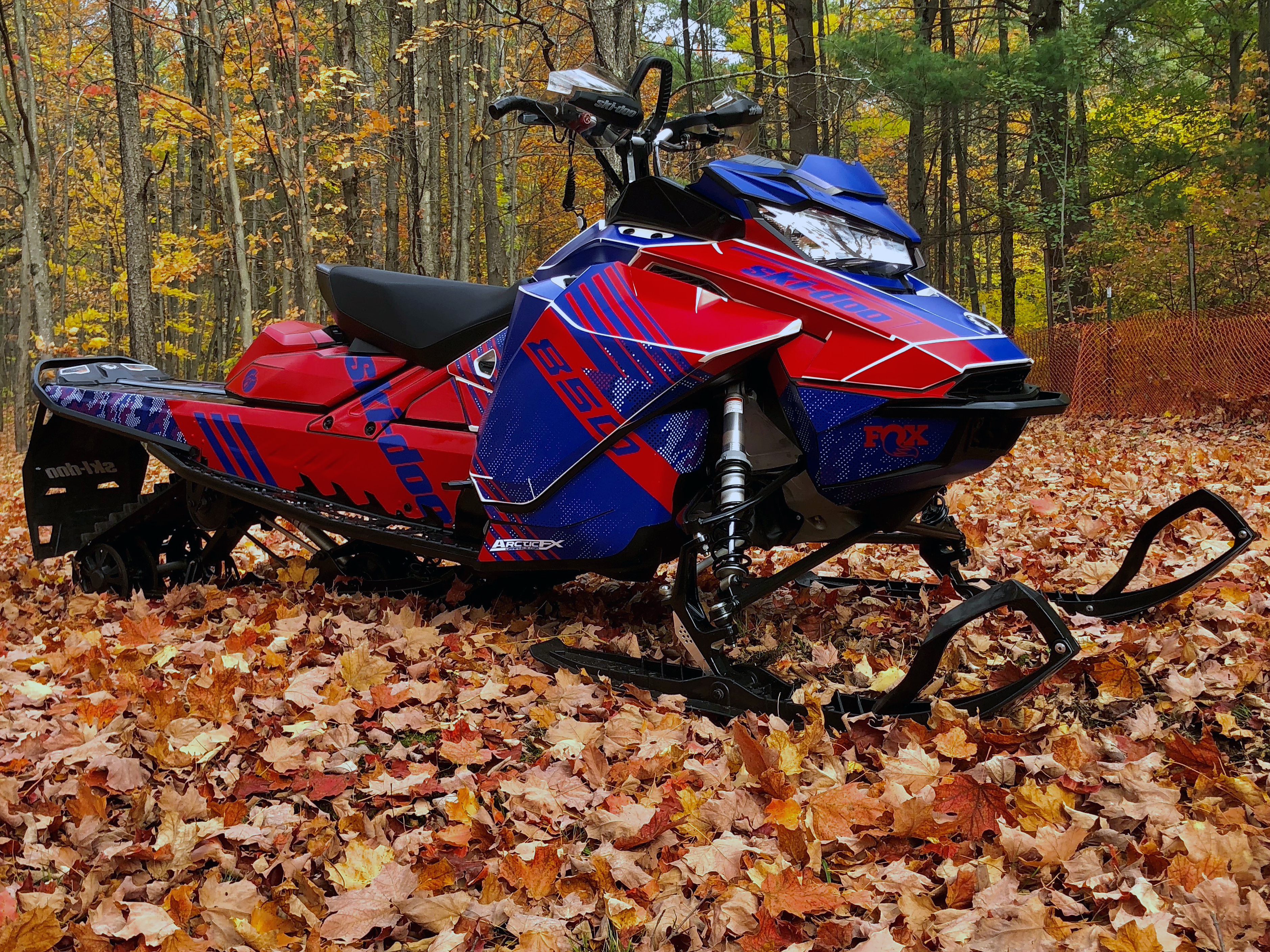 A Ski-Doo Gen4 Narrow Body snowmobile with a blue, red, and white Armada custom vinyl wrap.
