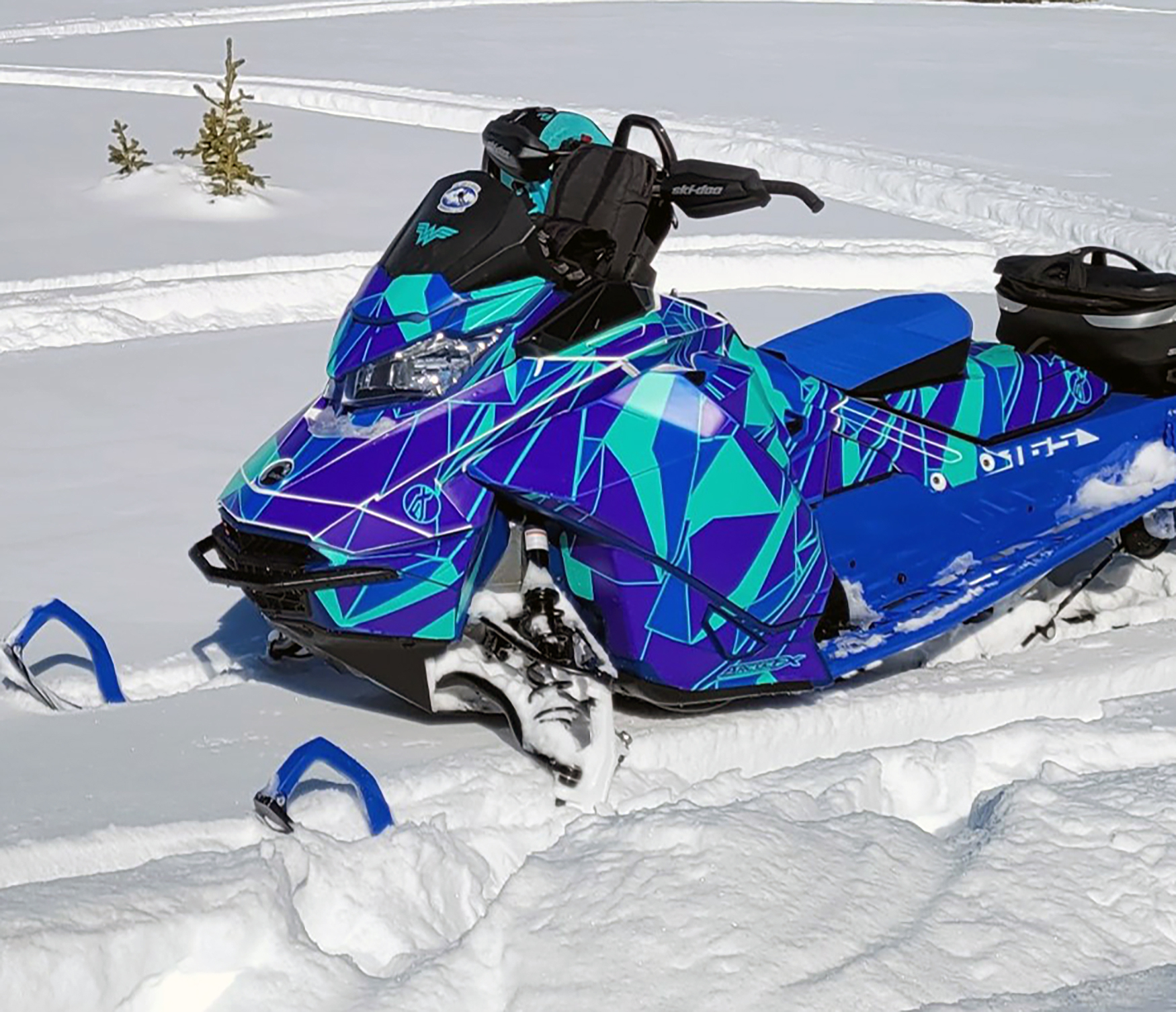 A Ski-Doo Gen4 Narrow Body snowmobile with a blue, aqua, and purple Ascension custom vinyl wrap.