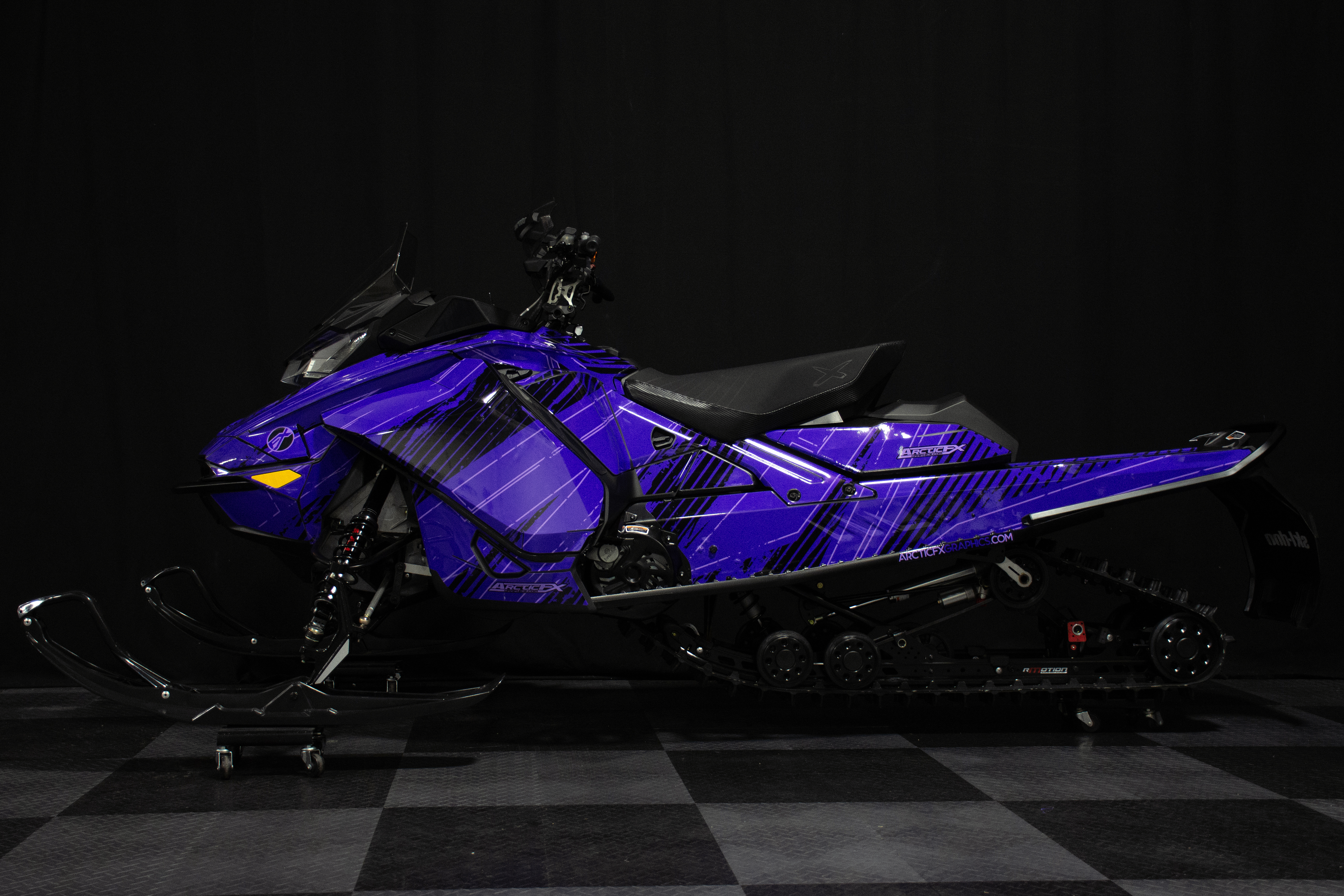 A Ski-Doo Gen4 Narrow Body snowmobile with a purple and black Blackout custom vinyl wrap.