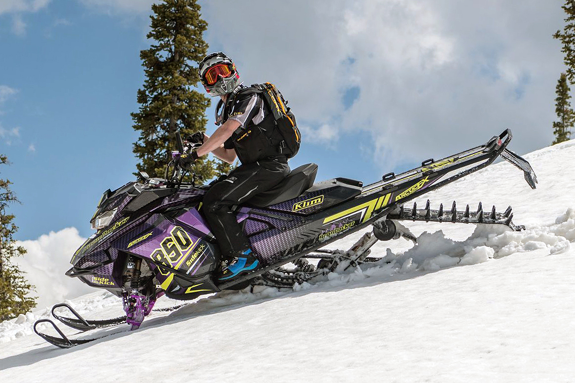 A Ski-Doo Gen4 Narrow Body snowmobile with a purple, yellow, and black BD Spooled custom vinyl wrap.
