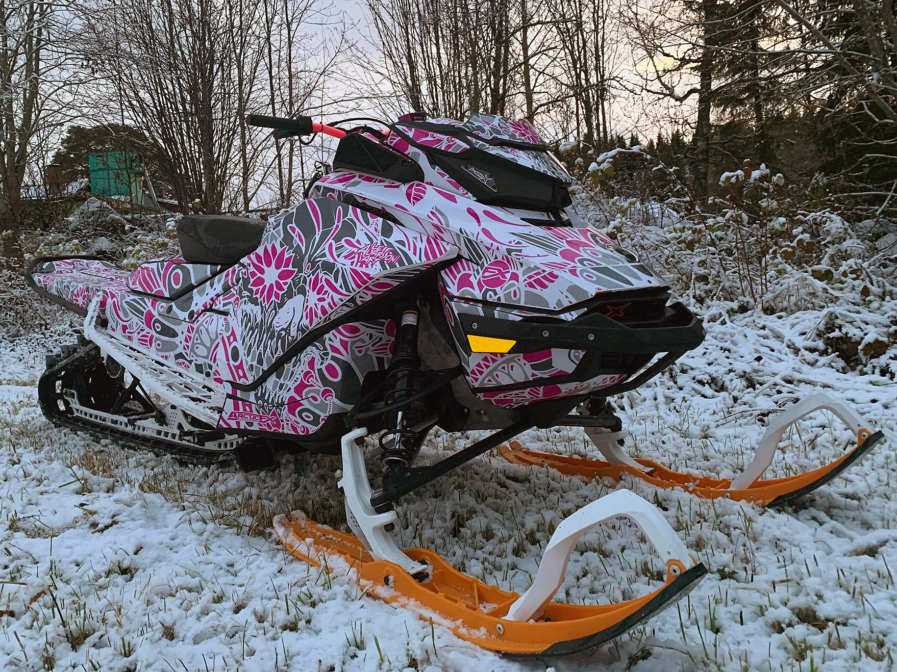 A Ski-Doo Gen4 Narrow Body snowmobile with a white, gray, and pink Leif Alvarsson Calavera custom vinyl wrap.