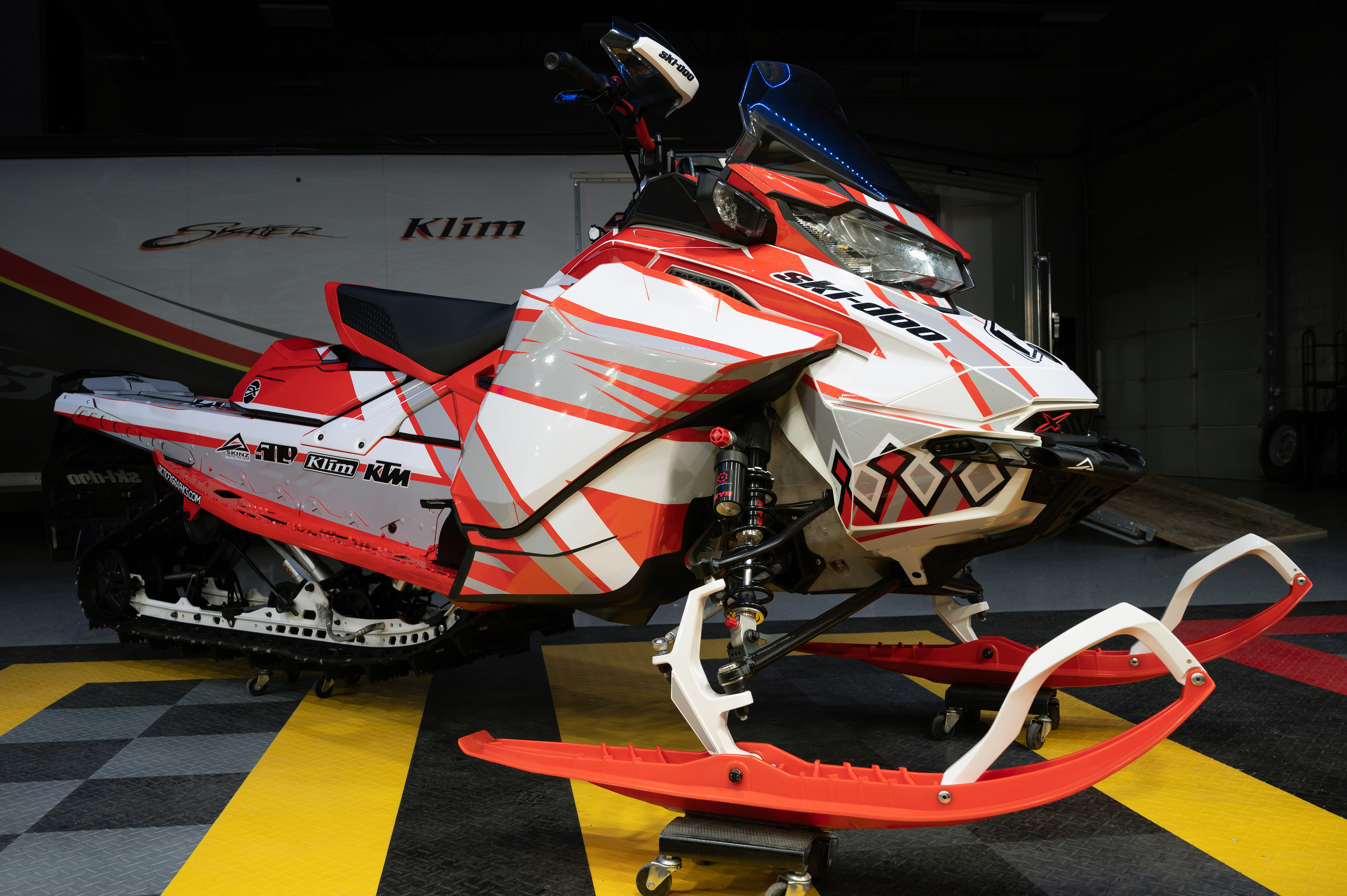 A Ski-Doo Gen4 Narrow Body snowmobile with a red, gray, and white Curtis Mountain King custom vinyl wrap.