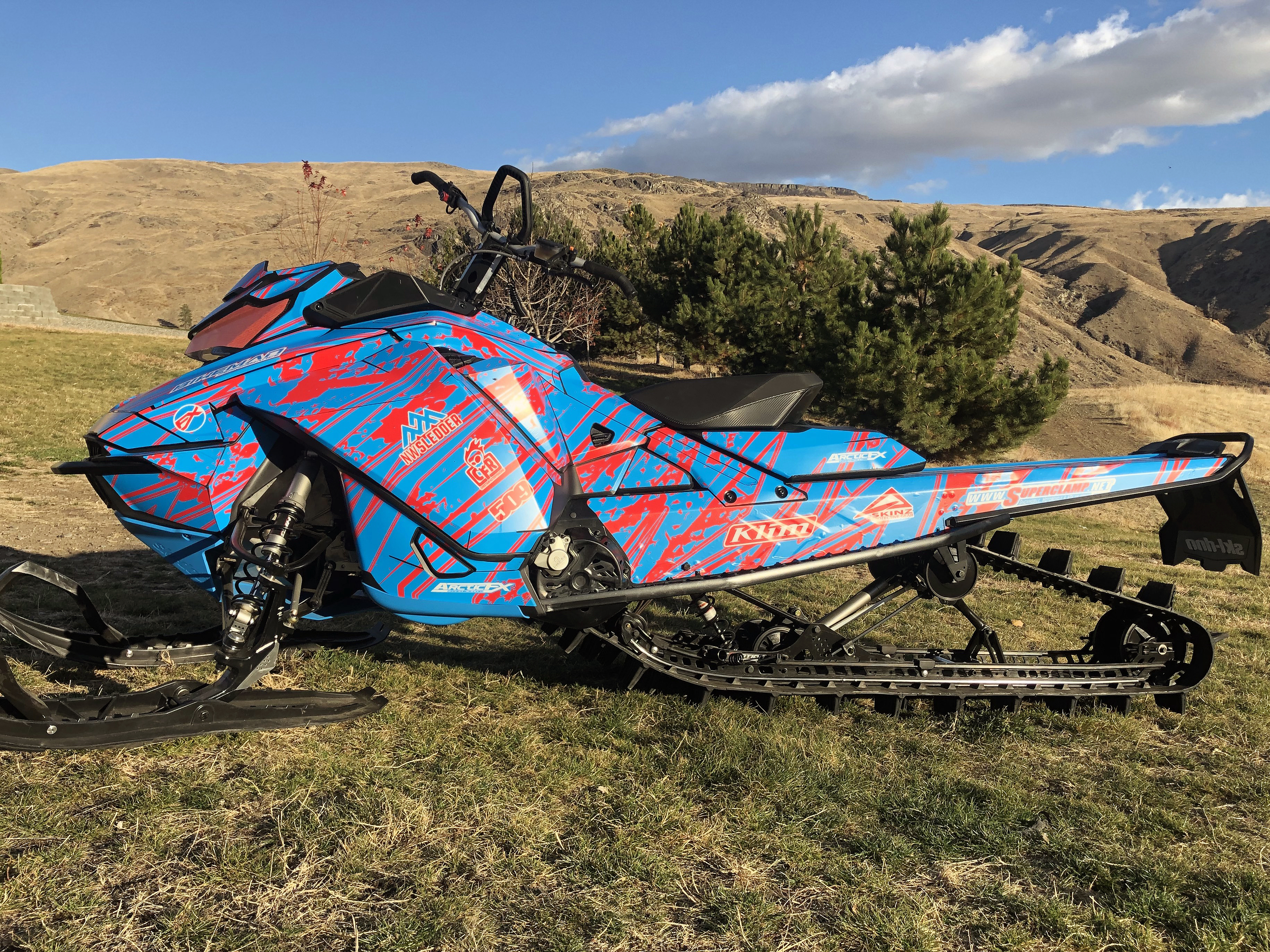 A Ski-Doo Gen4 Narrow Body snowmobile with a red and blue Dangerzone custom vinyl wrap.