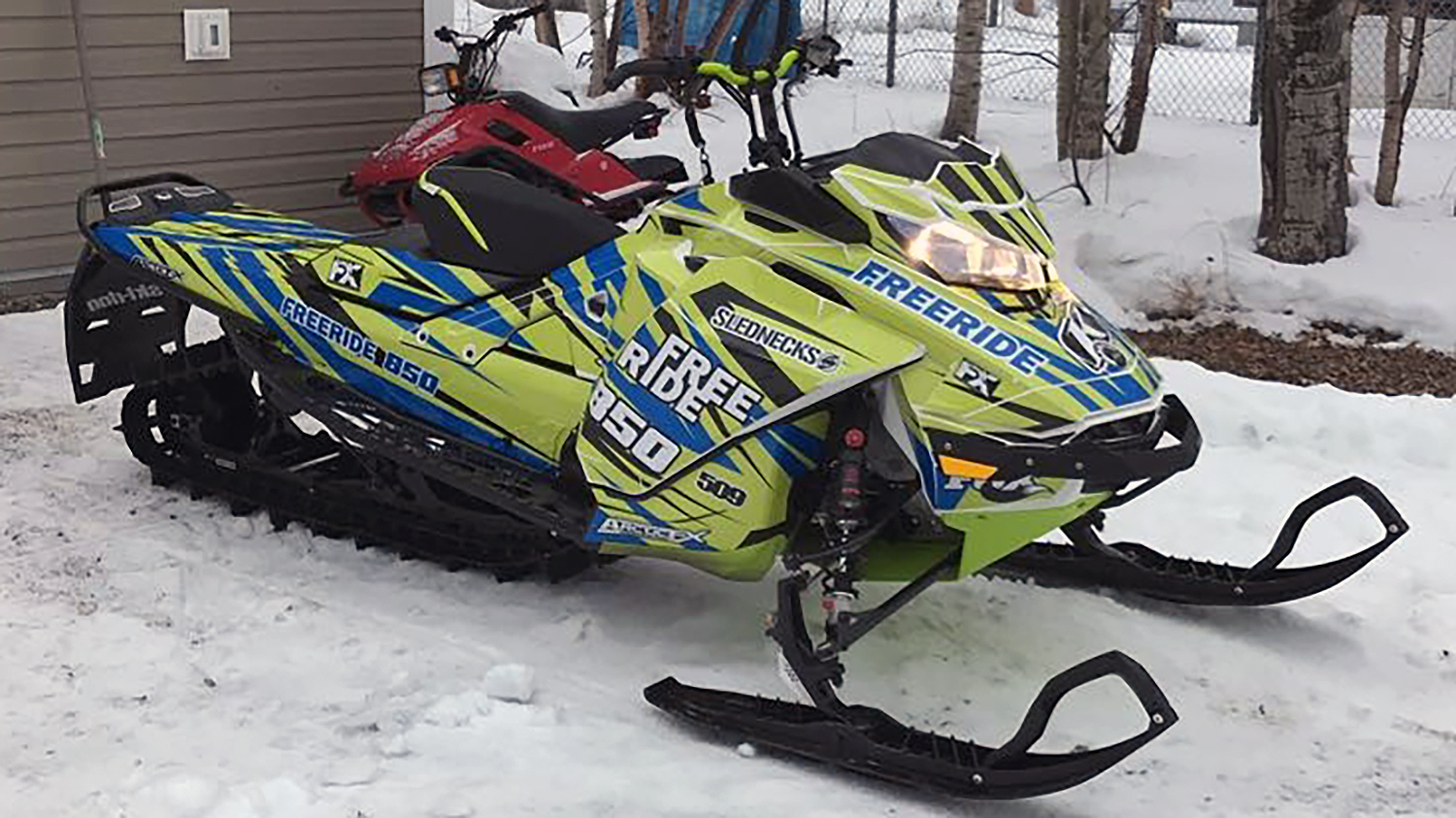 A Ski-Doo Gen4 Narrow Body snowmobile with a blue, black, and manta Burandt Evolution custom vinyl wrap.