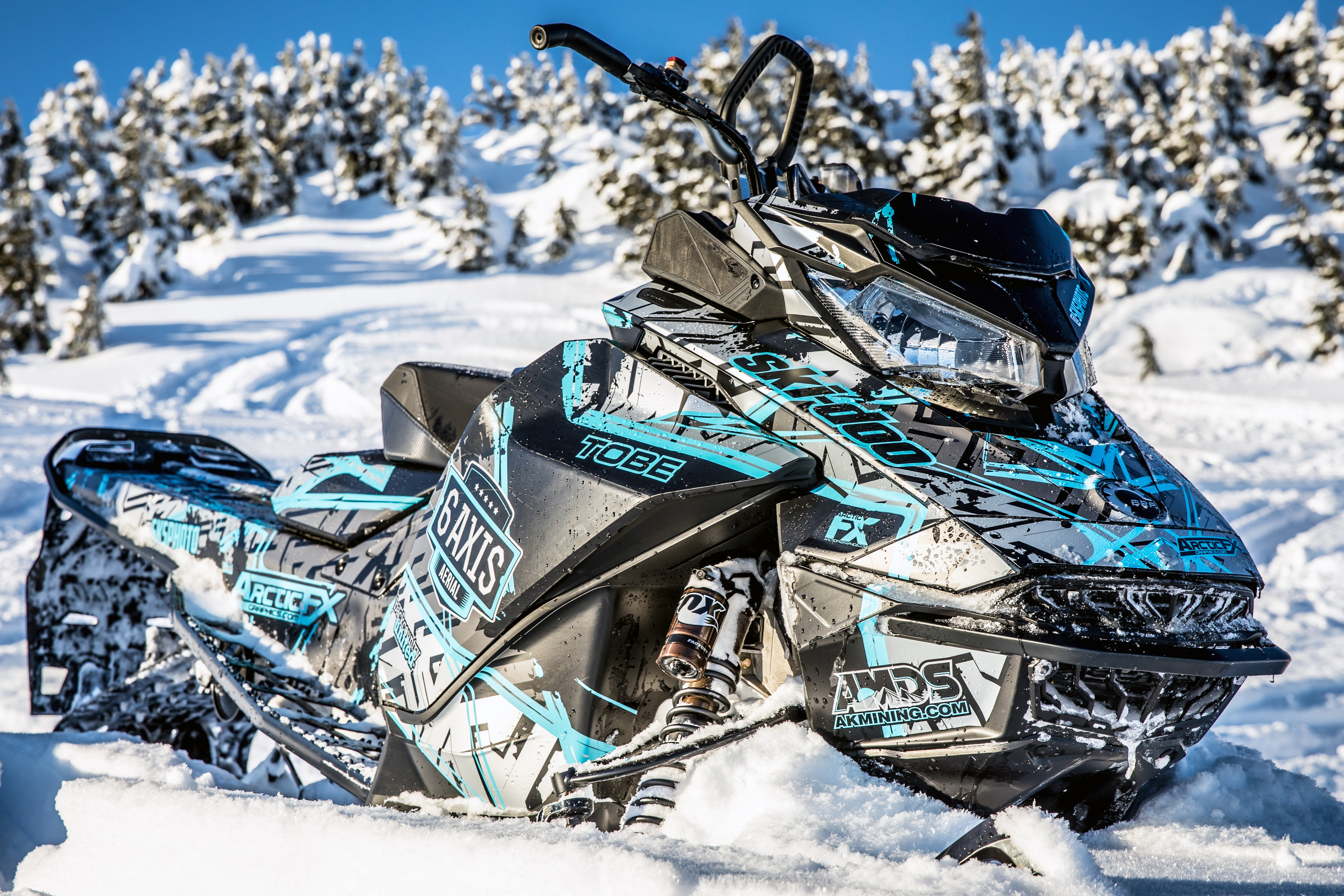 A Ski-Doo Gen4 Narrow Body snowmobile with a black, gray, and blue Havoc custom vinyl wrap.