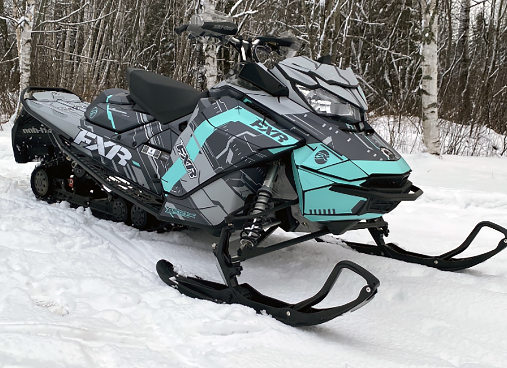 A Ski-Doo Gen4 Narrow Body snowmobile with a aqua, gray, and black Klim Recoil custom vinyl wrap.