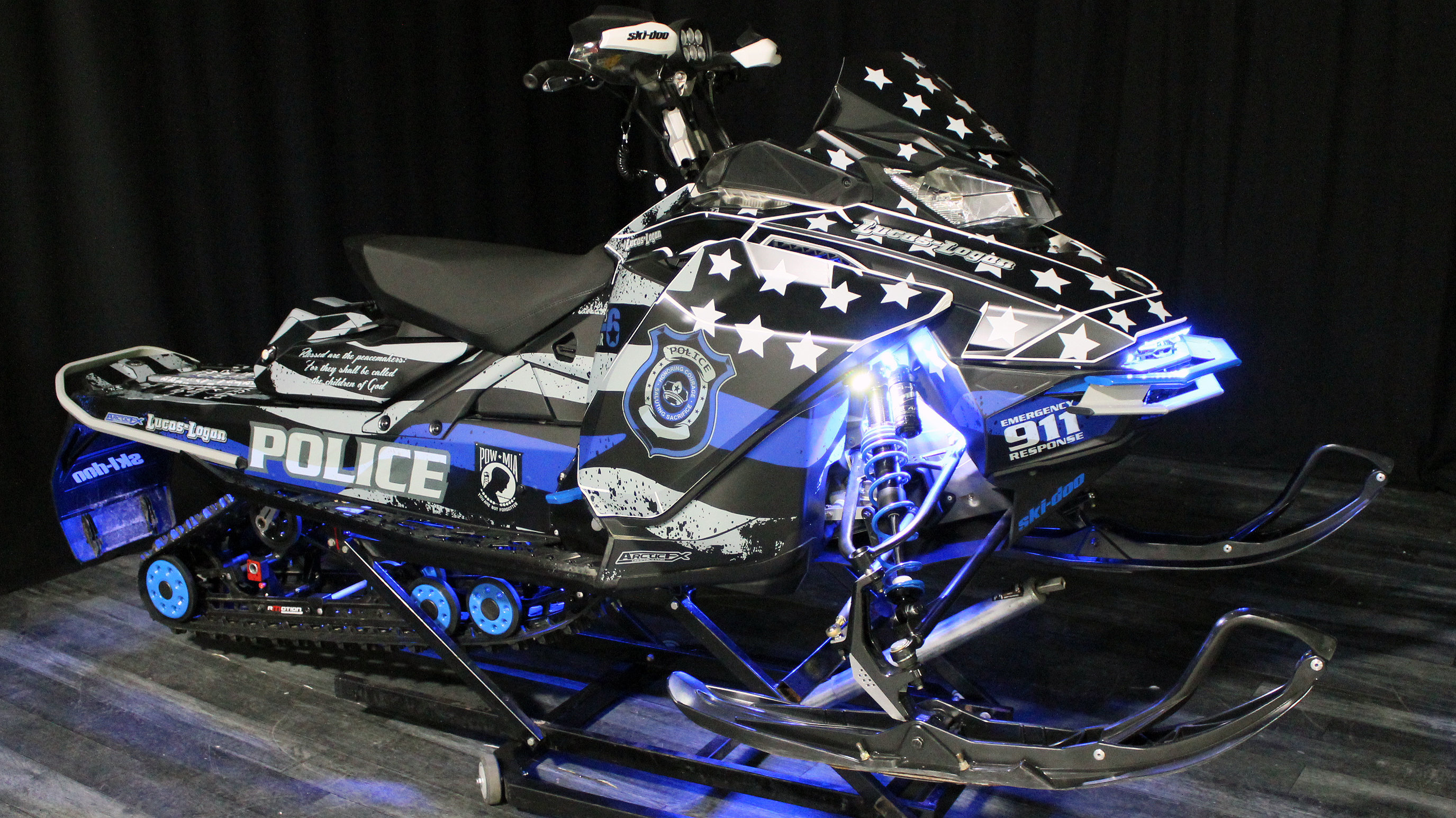 A Ski-Doo Gen4 Narrow Body snowmobile with a blue, gray, and black Police Flag custom vinyl wrap.