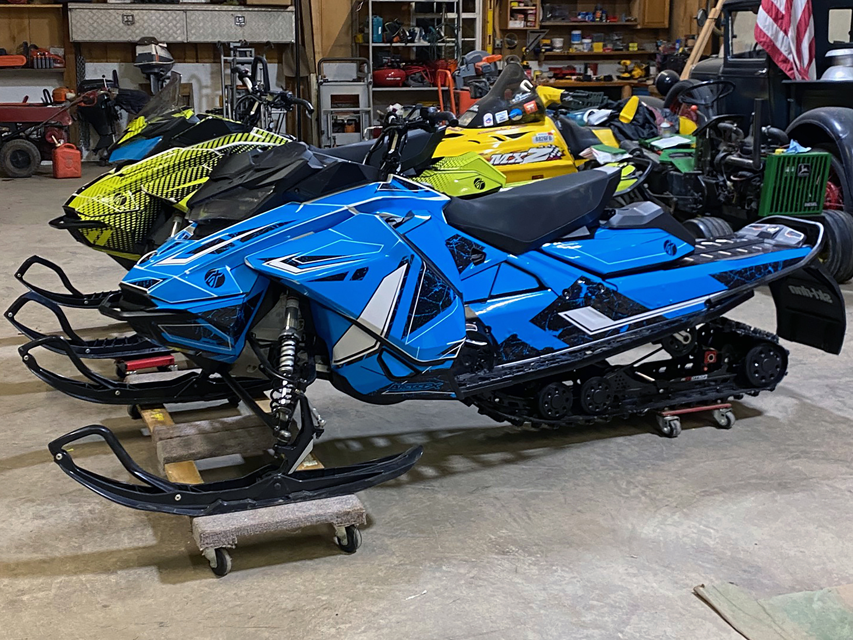 A Ski-Doo Gen4 Narrow Body snowmobile with a blue, white, and black Rogue custom vinyl wrap.