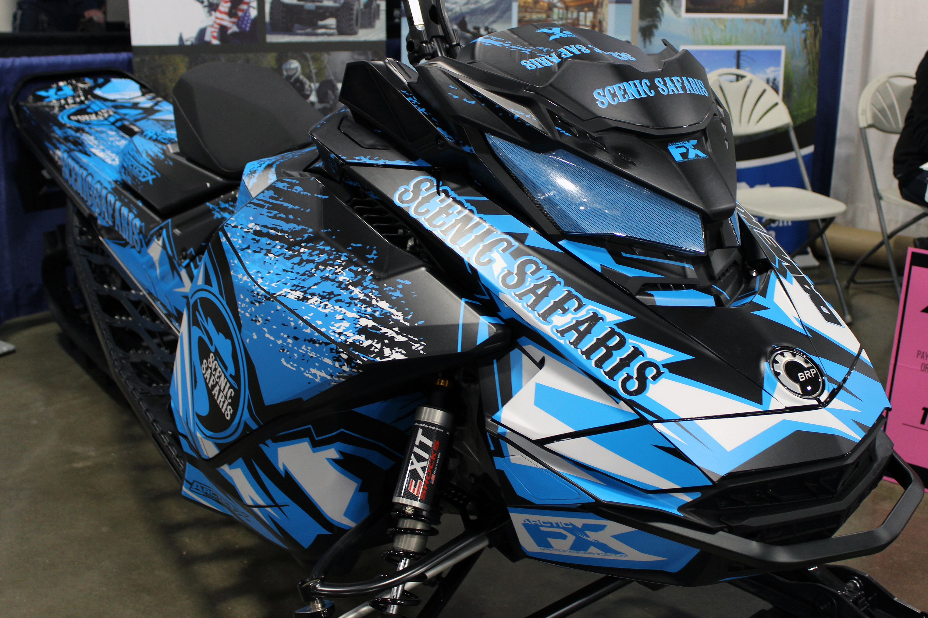 A Ski-Doo Gen4 Narrow Body snowmobile with a octane blue, white, and black Scenic Safaris custom vinyl wrap.