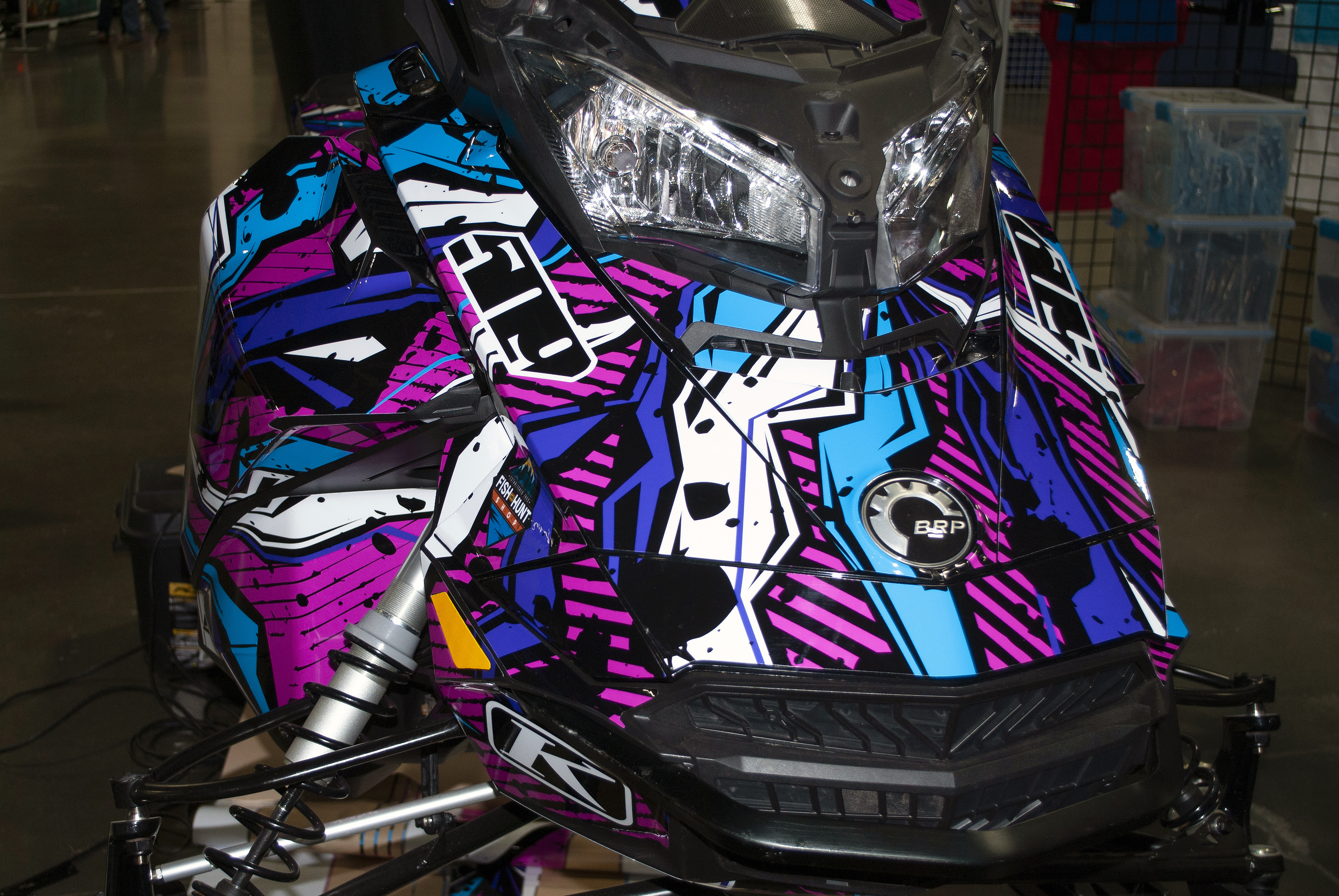 A Ski-Doo Gen4 Narrow Body snowmobile with a pink, blue, and black Stricken custom vinyl wrap.