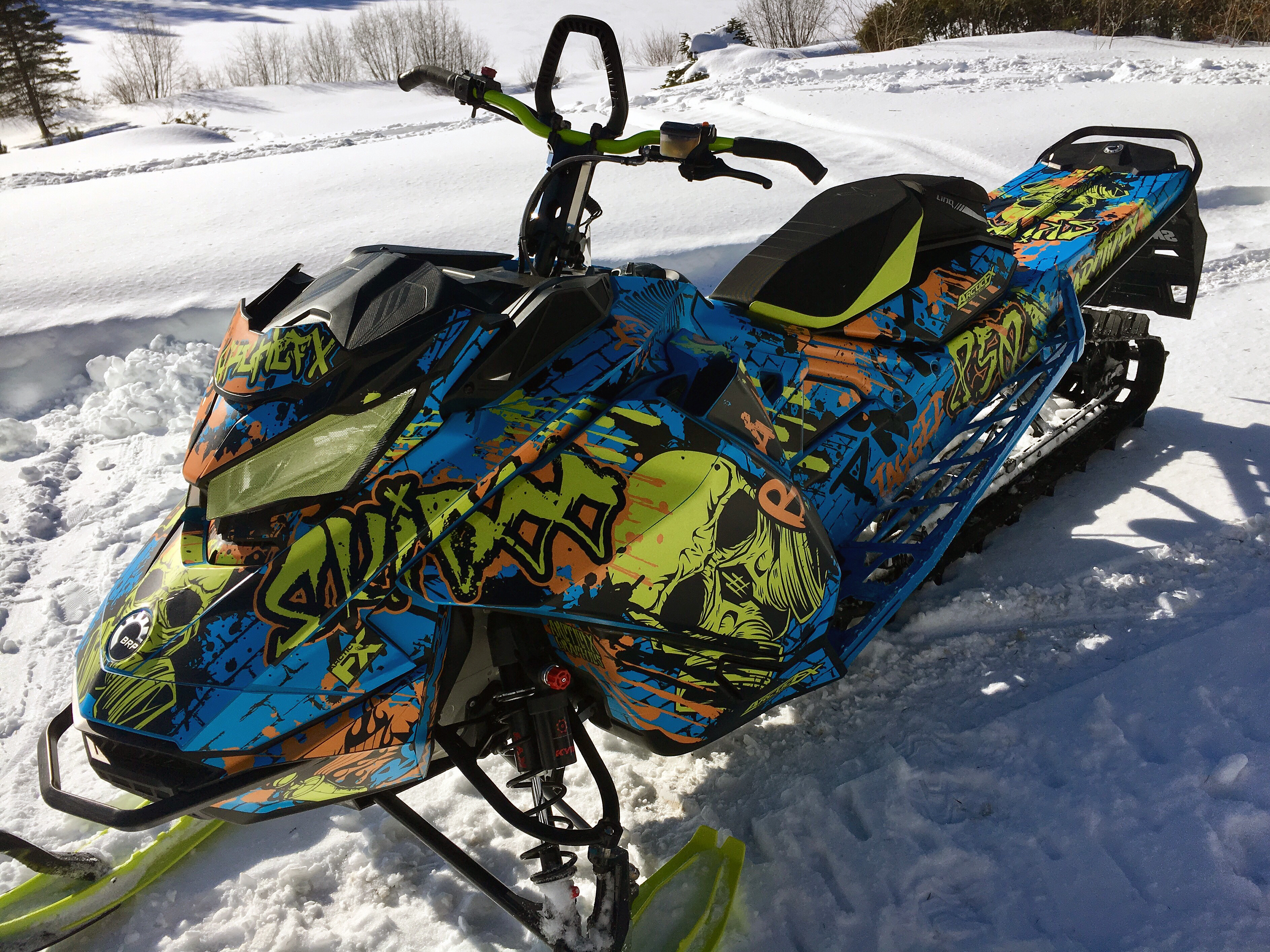 A Ski-Doo Gen4 Narrow Body snowmobile with a octane blue, manta, and orange Tagged custom vinyl wrap.