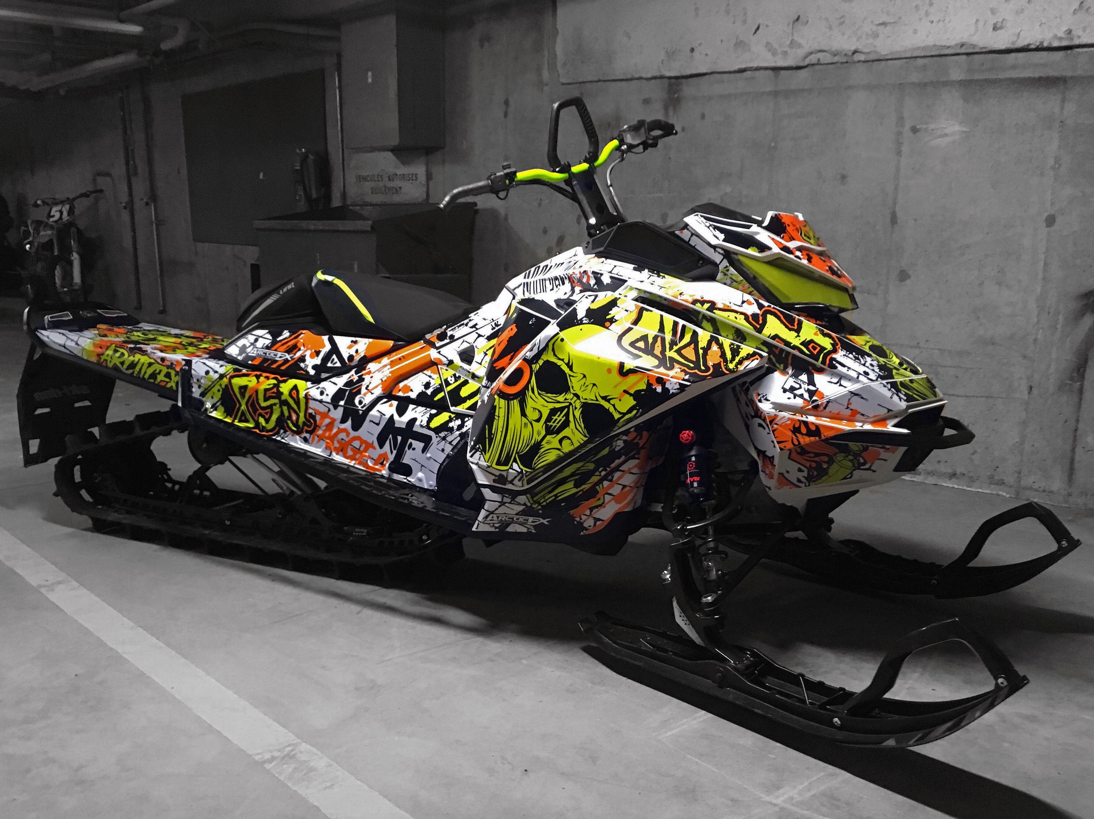 A Ski-Doo Gen4 Narrow Body snowmobile with a orange, manta, and white Tagged custom vinyl wrap.