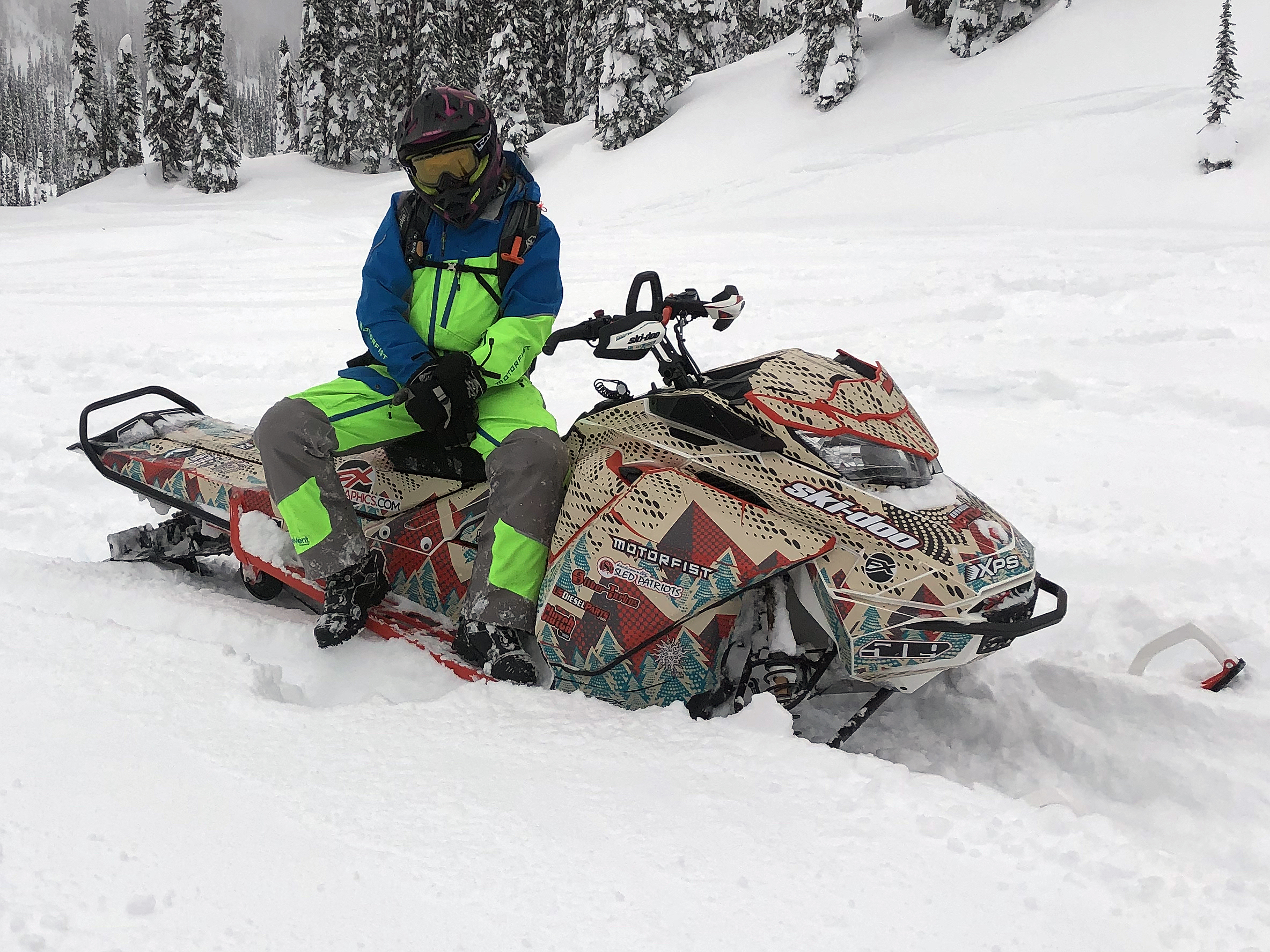 A Ski-Doo Gen4 Narrow Body snowmobile with a red, tan, and gray Vertex custom vinyl wrap.