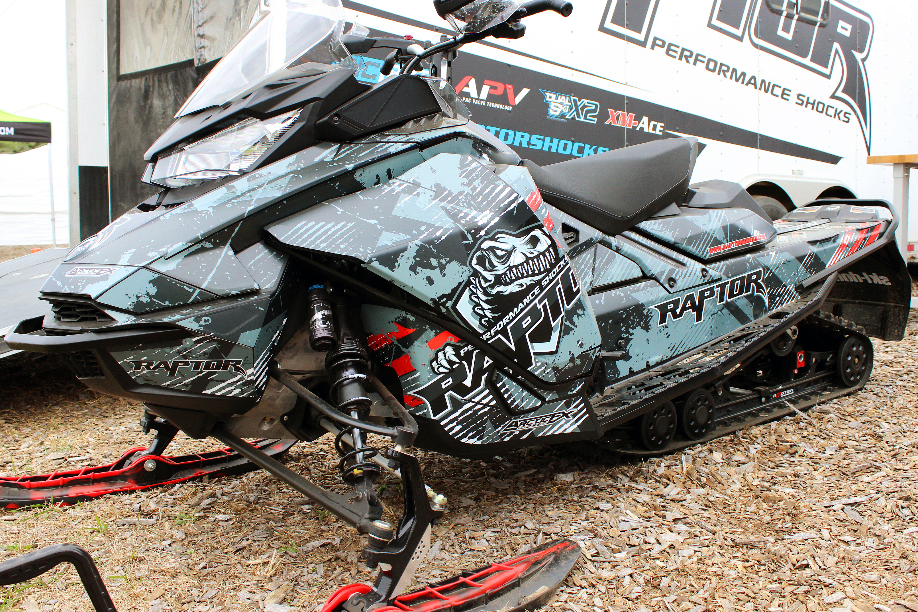 A Ski-Doo Gen4 Narrow Body snowmobile with a gray, red, and black Wartorn custom vinyl wrap.