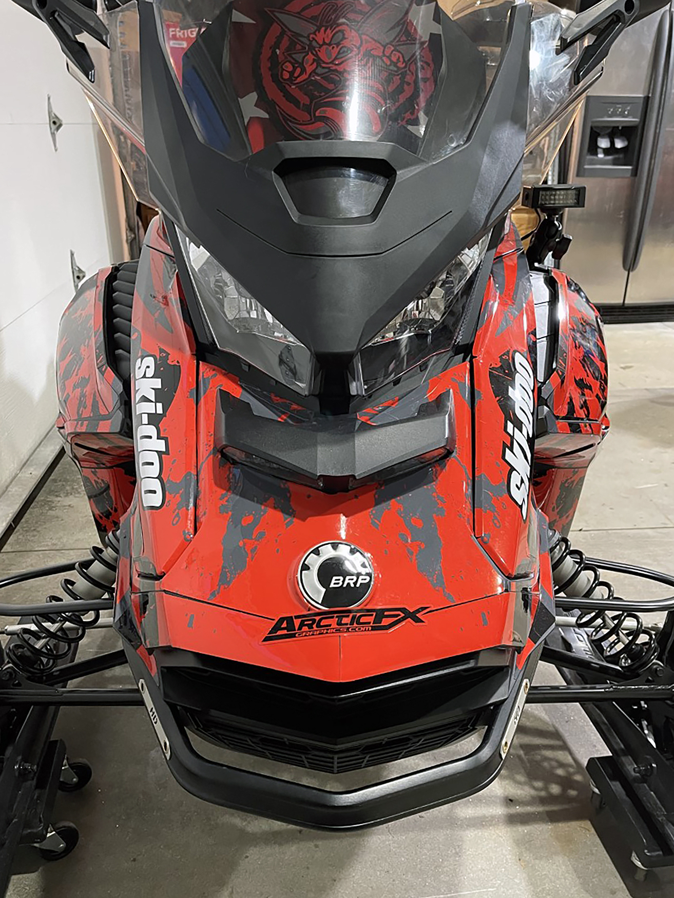 A Ski-Doo Gen4 Wide Body snowmobile with a red, gray, and black American Flag custom vinyl wrap.
