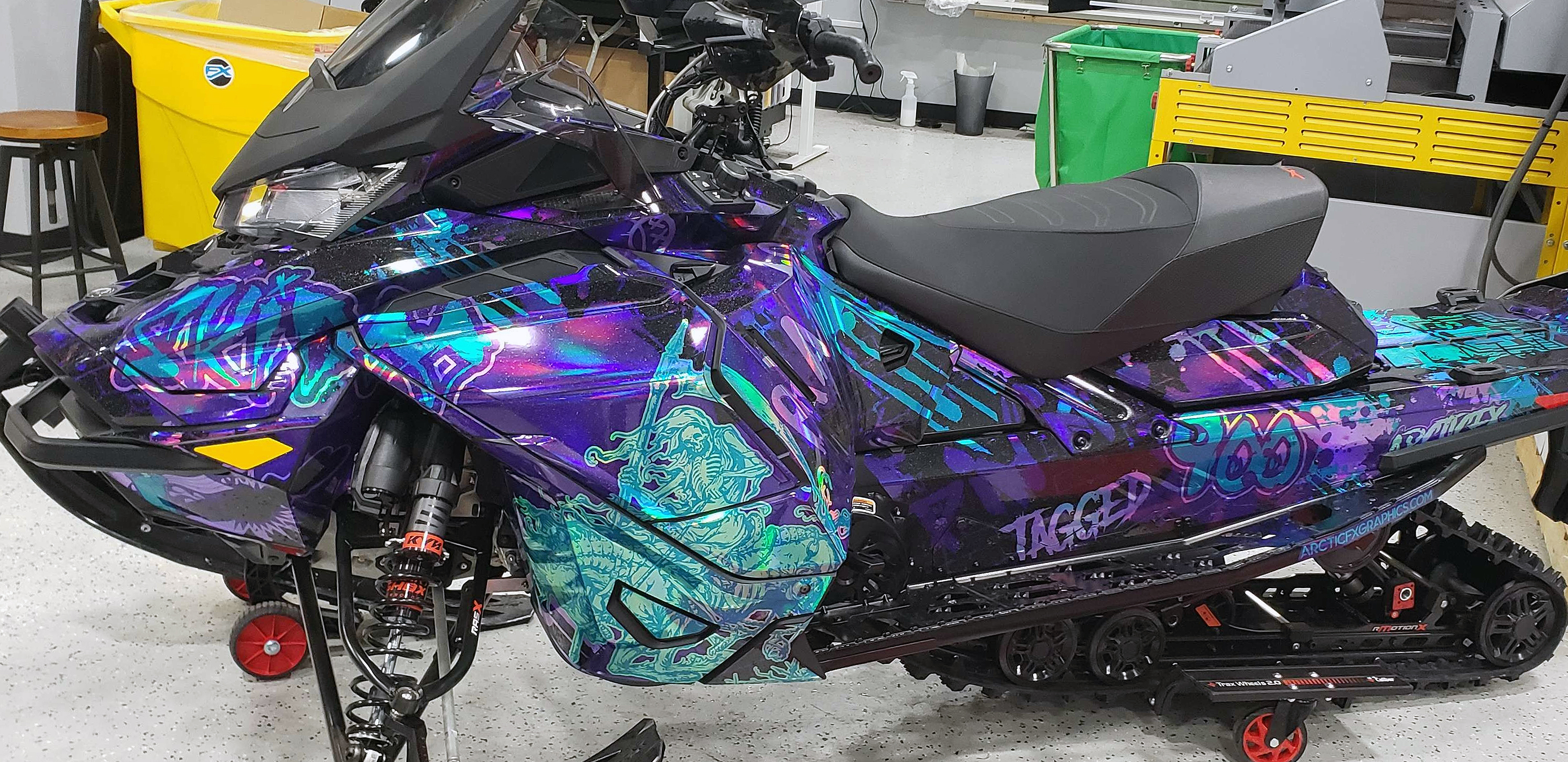 A Ski-Doo Gen4 Wide Body snowmobile with a aqua, purple, and chrome Tagged custom vinyl wrap.