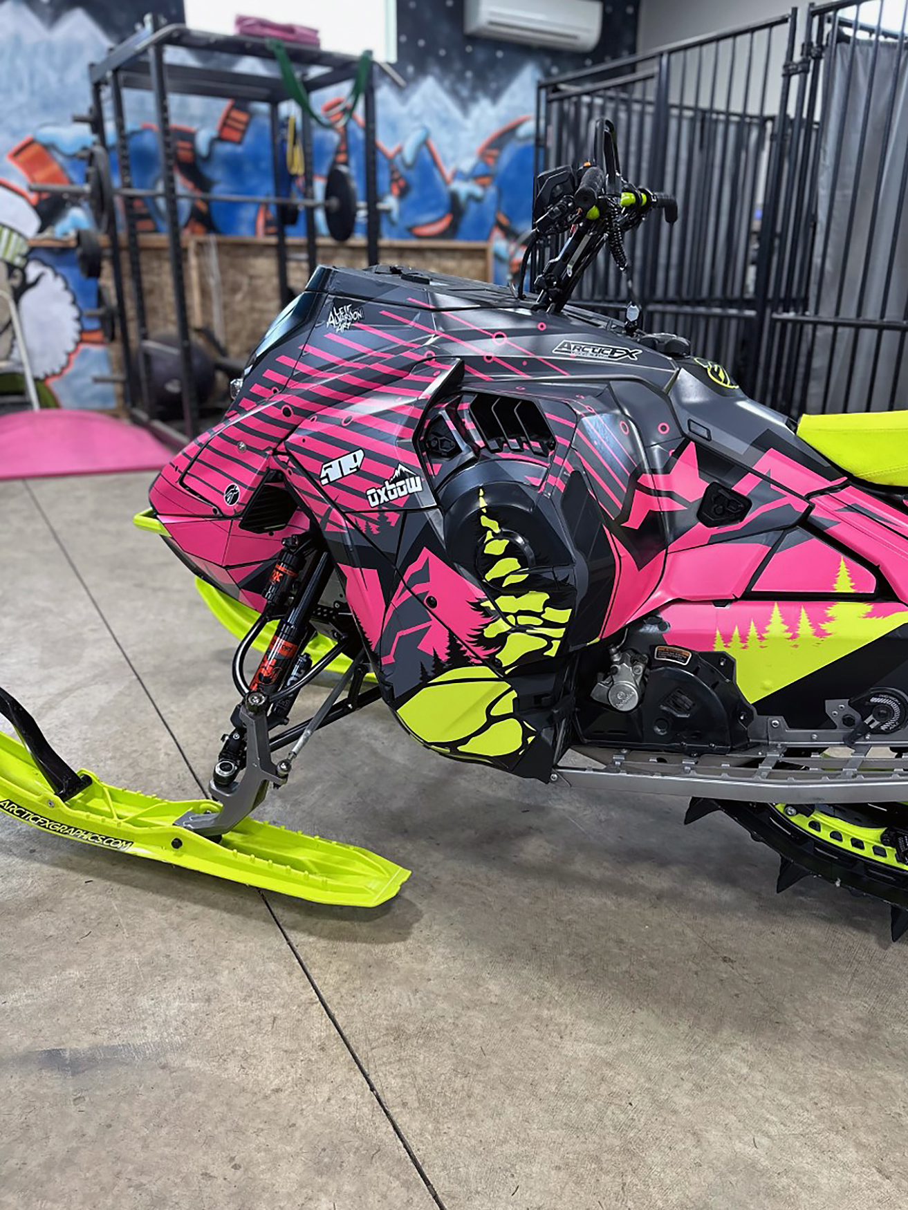 A Ski-Doo Gen5 Mountain snowmobile with a lime squeeze, pink, and black Leif Alvarsson Kingdom custom vinyl wrap.