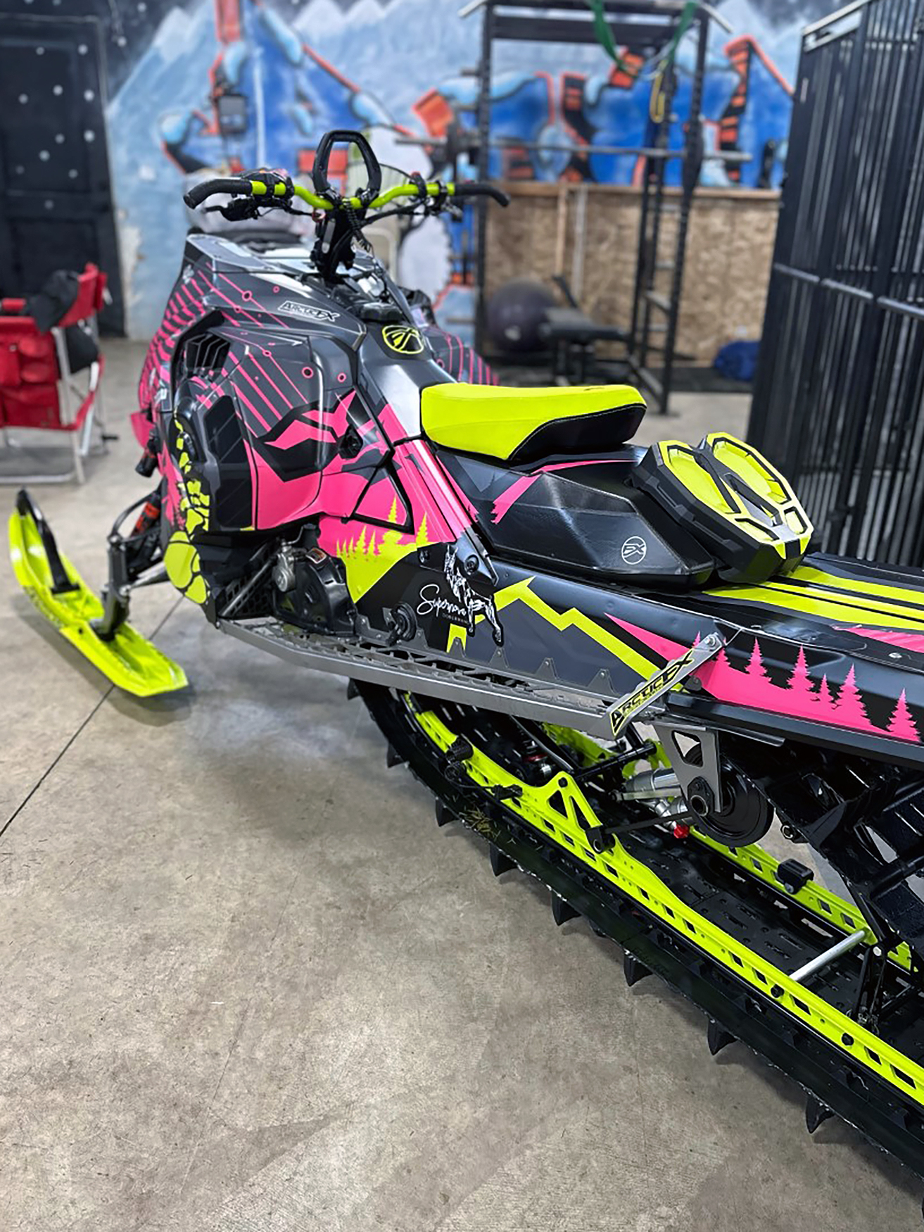 A Ski-Doo Gen5 Mountain snowmobile with a lime squeeze, pink, and black Leif Alvarsson Kingdom custom vinyl wrap.