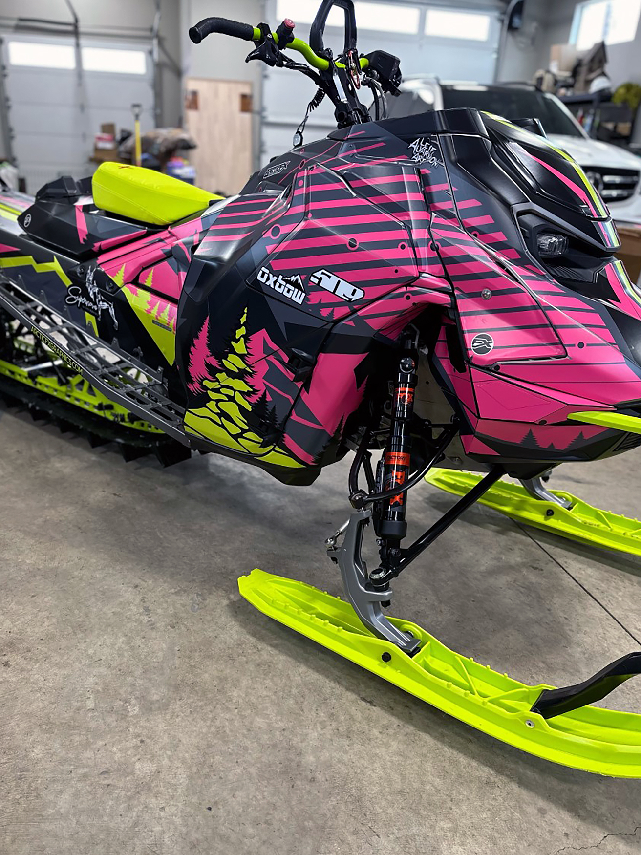 A Ski-Doo Gen5 Mountain snowmobile with a lime squeeze, pink, and black Leif Alvarsson Kingdom custom vinyl wrap.