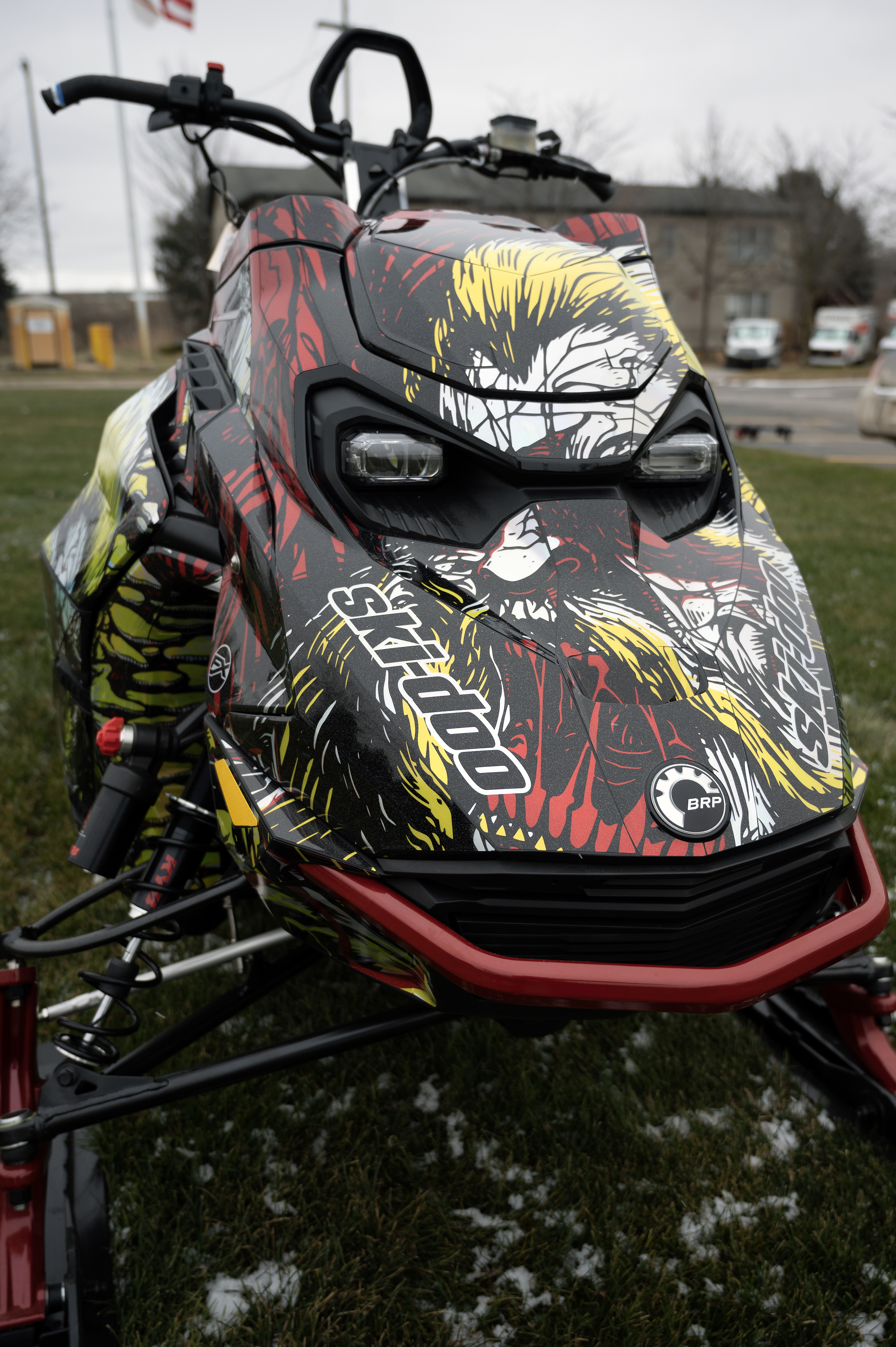 A Ski-Doo Gen5 Mountain snowmobile with a chrome, red, black, and lime squeeze Leif Alvarsson Tree Slayer custom vinyl wrap.