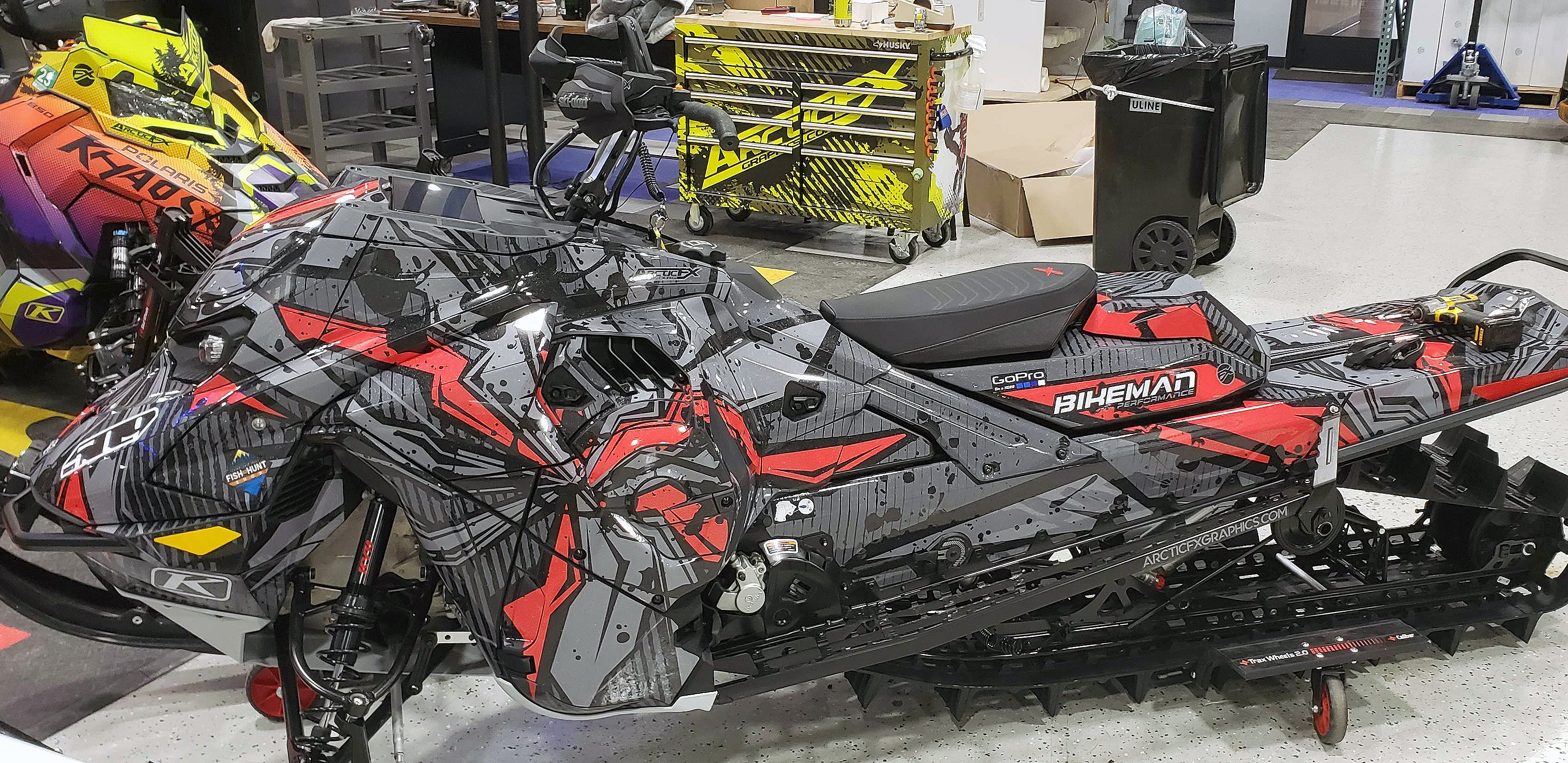 A Ski-Doo Gen5 Mountain snowmobile with a black, red, and gray Stricken custom vinyl wrap.
