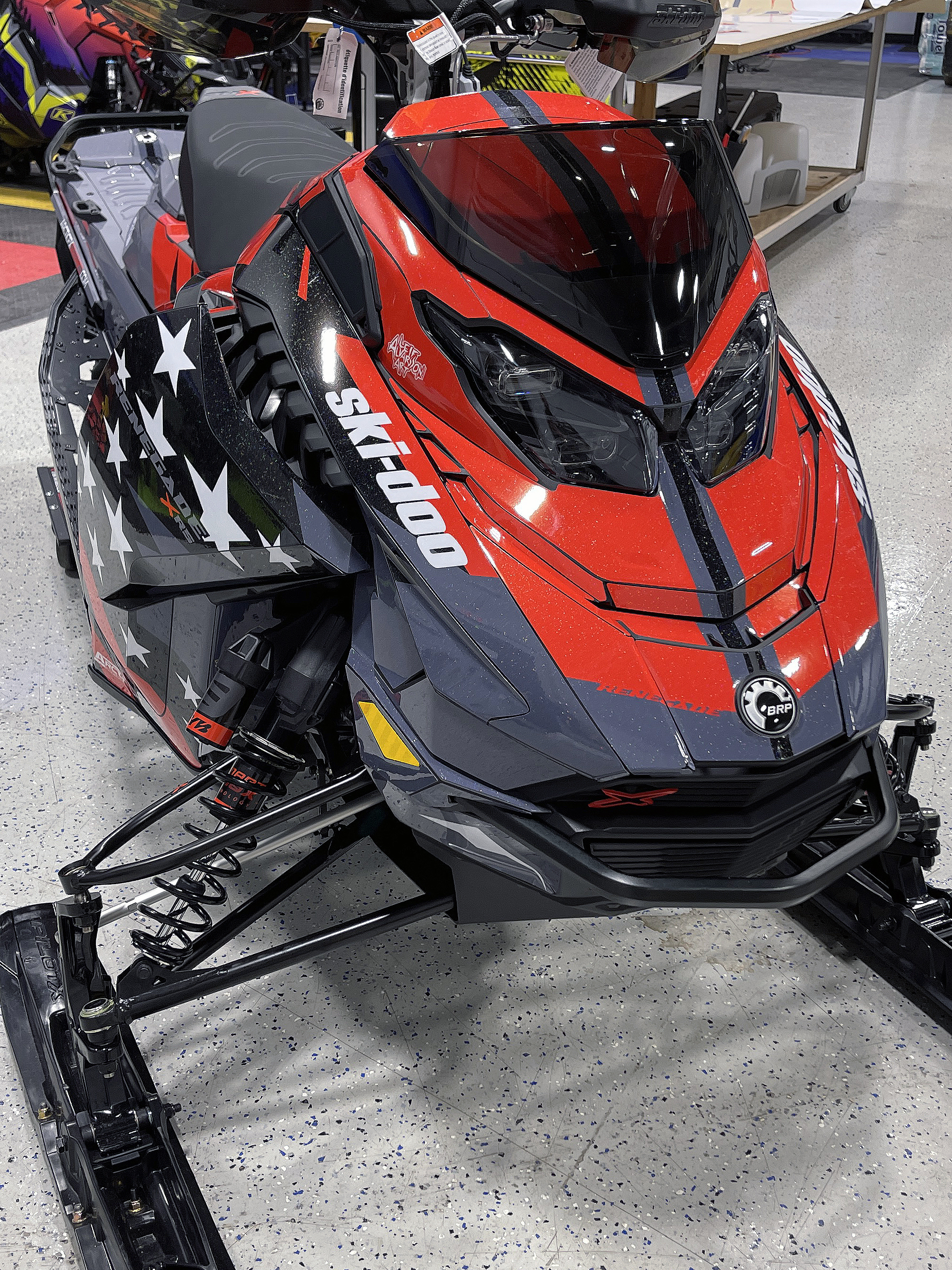 A Ski-Doo Gen5 Trail snowmobile with a red, white, and black Leif Alvarsson Merica custom vinyl wrap.