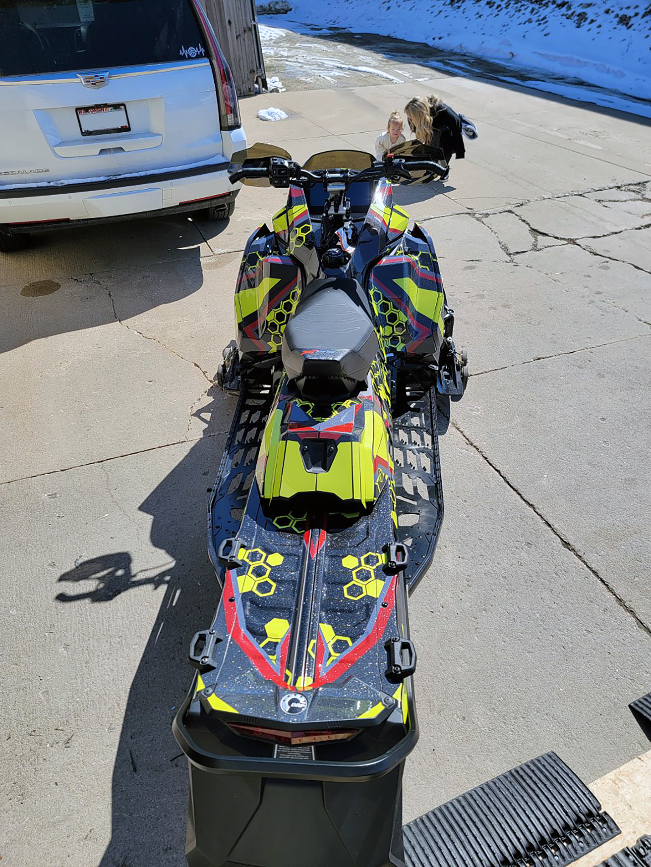A Ski-Doo Gen5 Trail snowmobile with a red, lime squeeze, and black Cody Monroe Incision custom vinyl wrap.