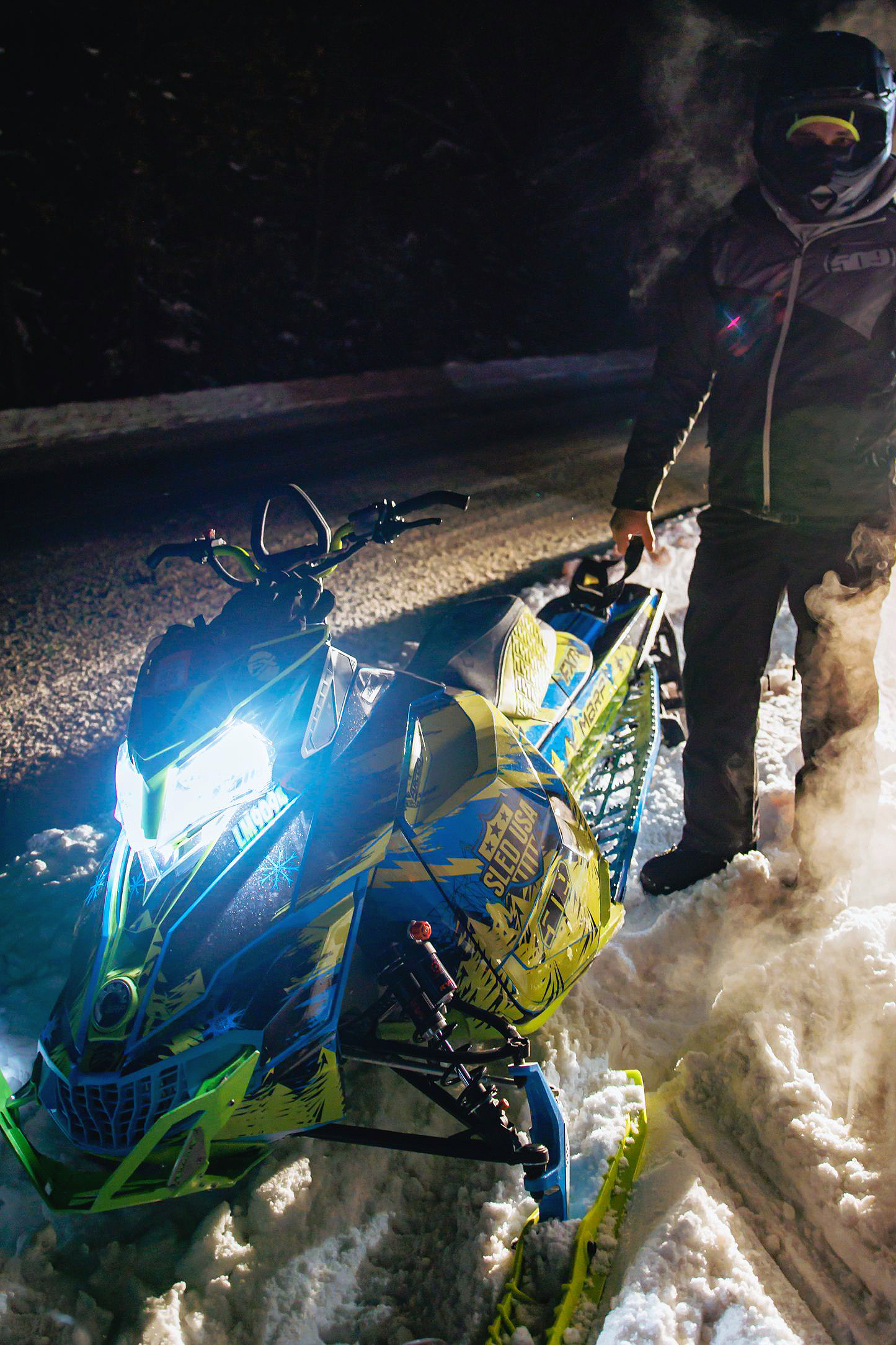 A Ski-Doo Rev XM snowmobile with a manta, octane blue, and black Absolute Zero custom vinyl wrap.
