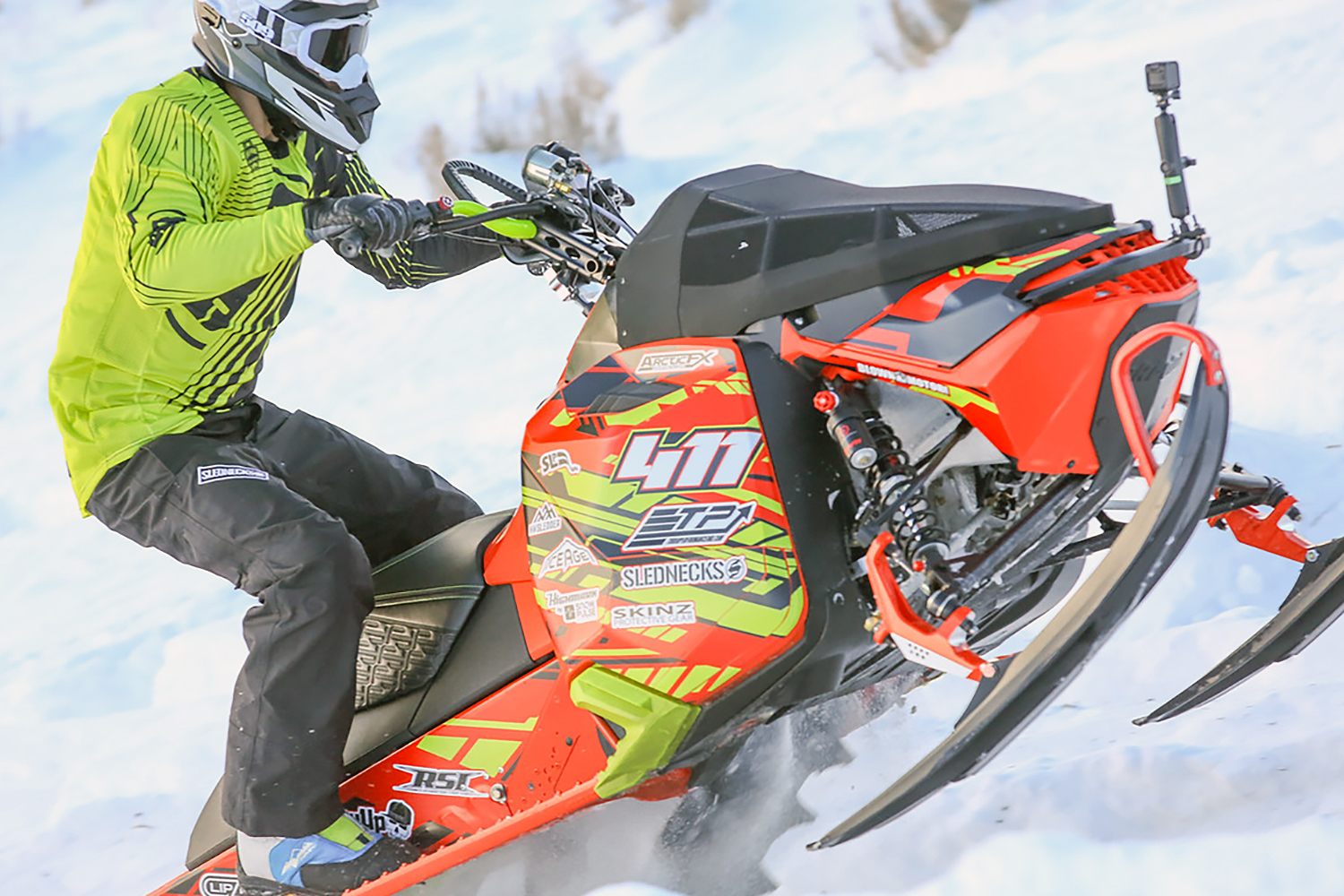 A Ski-Doo Rev XM snowmobile with a manta, red, and black Evasion custom vinyl wrap.