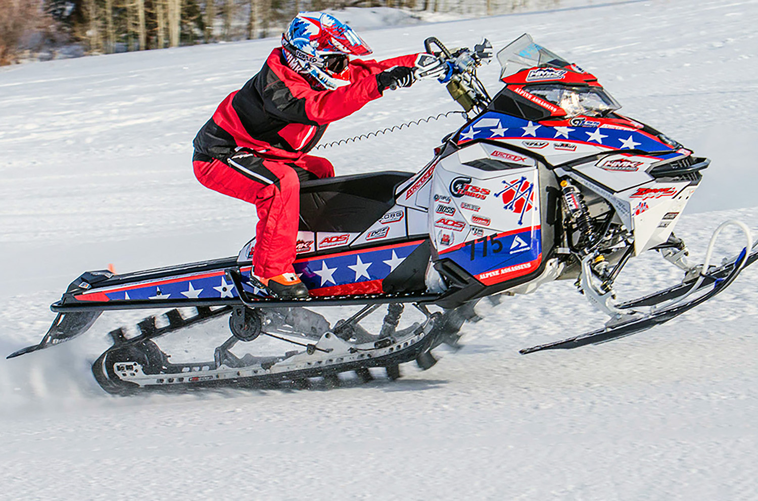 A Ski-Doo Rev XM snowmobile with a red, white, and blue Evil Knievel custom vinyl wrap.