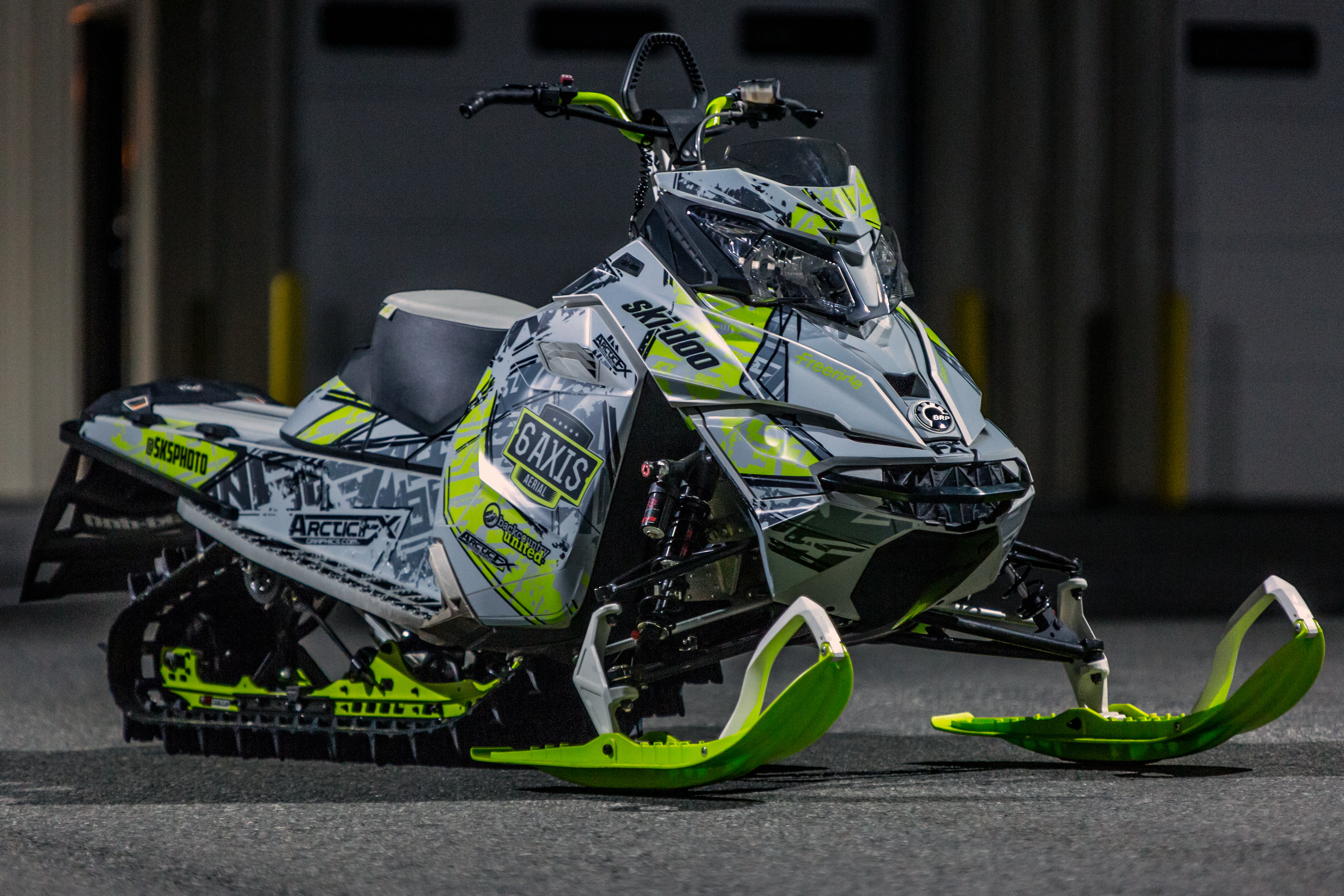 A Ski-Doo Rev XM snowmobile with a gray, black, and manta Havoc custom vinyl wrap.