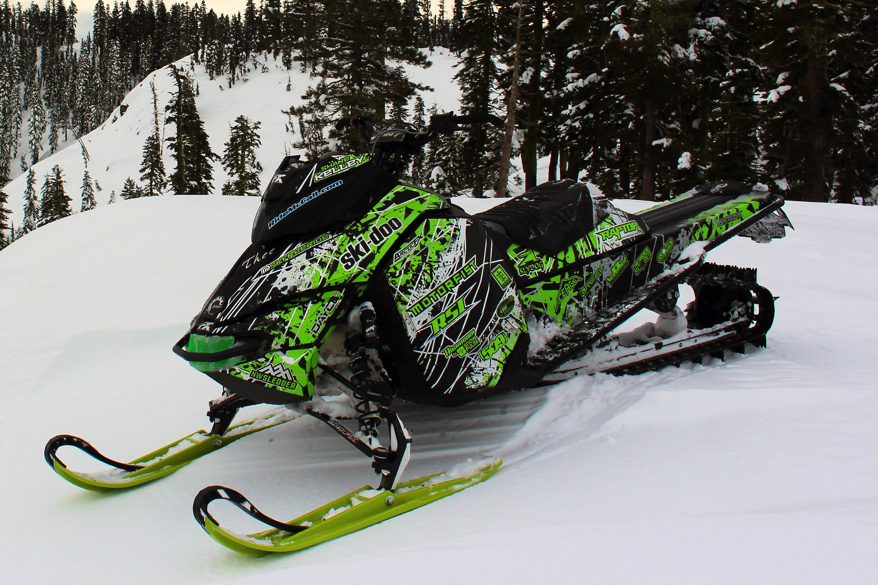 A Ski-Doo Rev XM snowmobile with a black, white, and manta Oblivion custom vinyl wrap.